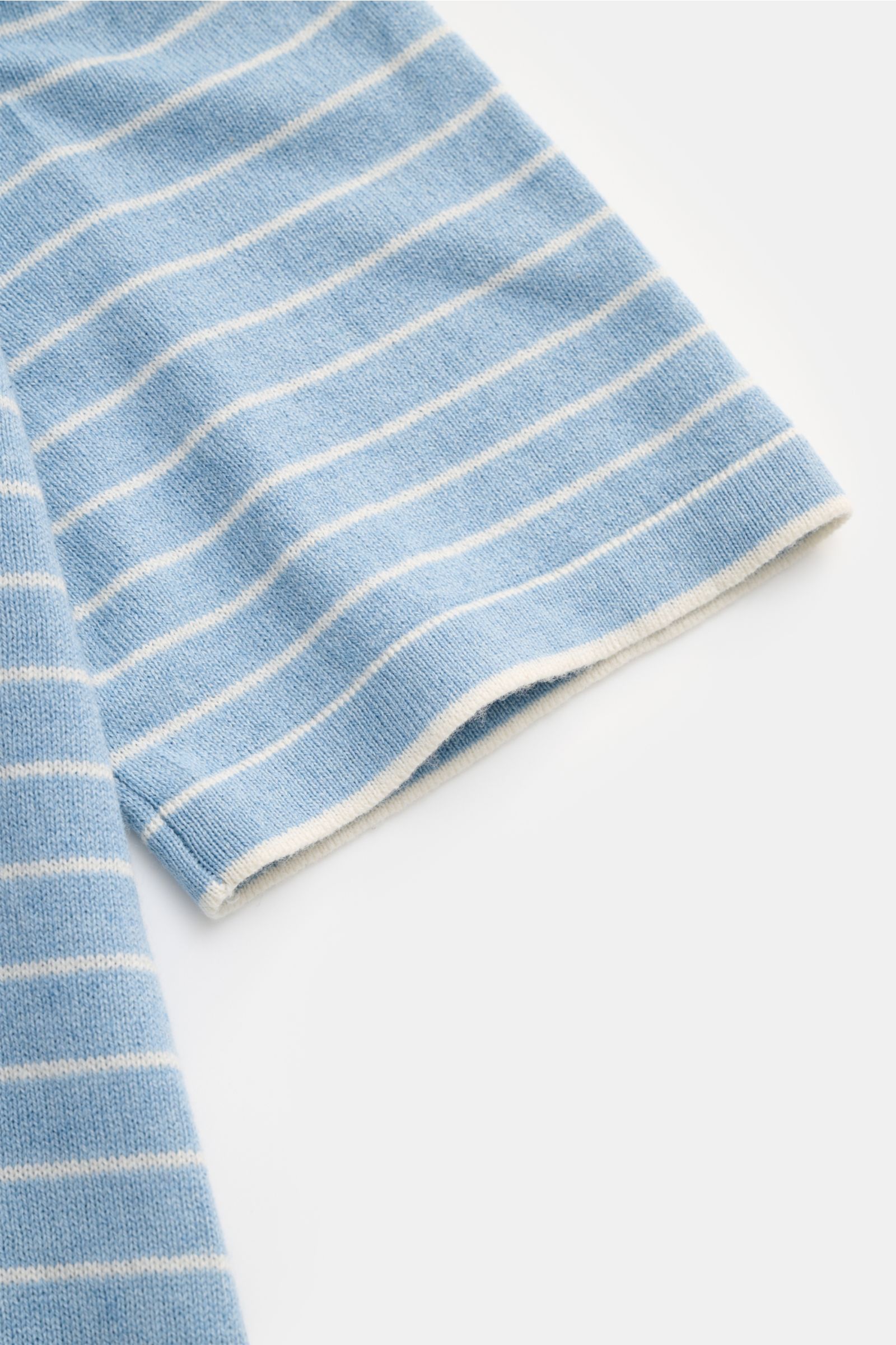 Nahaufnahme des Ärmels vom FTC Kurzarm-Rundhalspullover hellblau/weiß gestreift, luftiger Strick aus Cashmere-Baumwoll-SeaCell-Mix, soft, feines Strickbild, regular Fit, Rundhalsausschnitt, rollierter Saumabschluss.