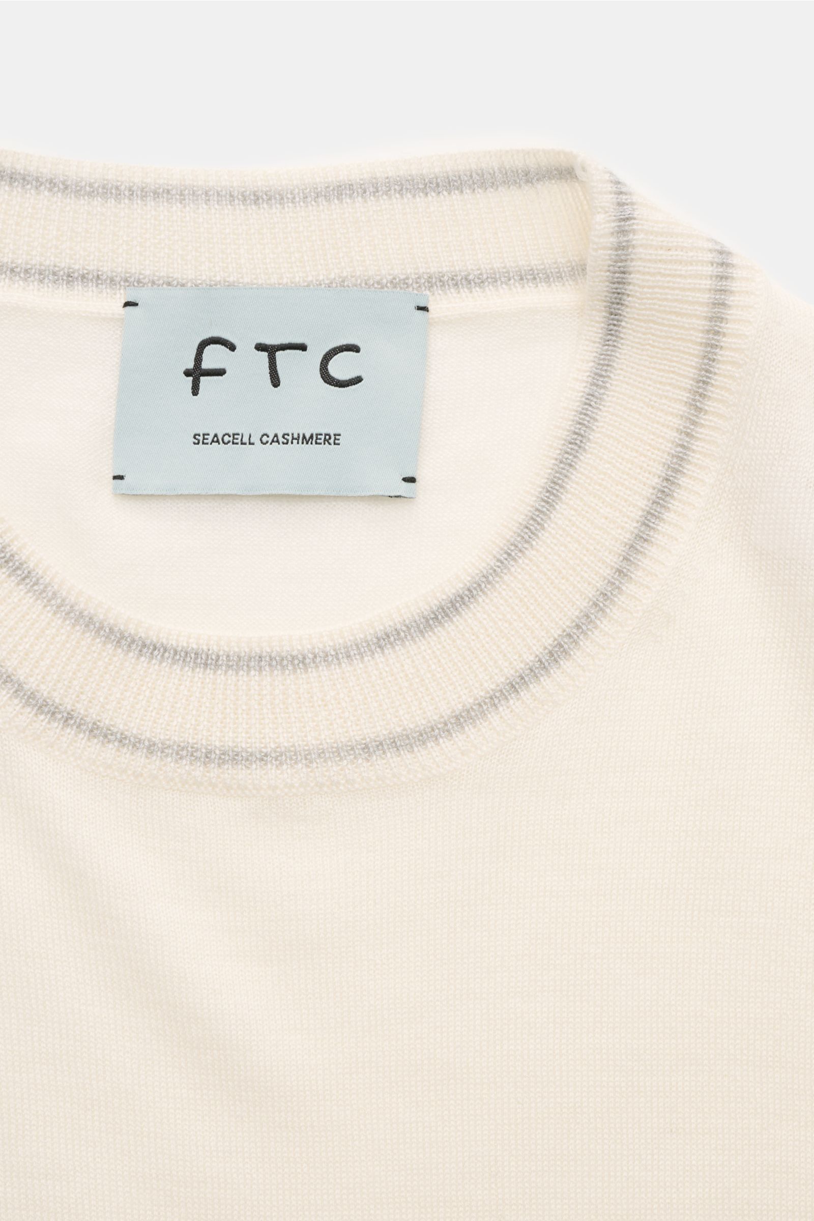 FTC Kurzarm-Rundhalspullover creme aus Cashmere-SeaCell-Mix, Nahaufnahme von oben, Slim Fit, Rundhalsausschnitt mit Kontraststreifen, öko-zertifiziert und nachhaltig.