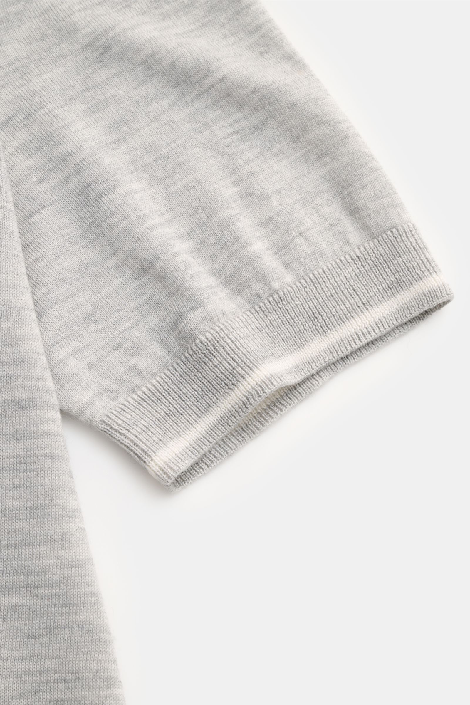 Nahaufnahme des FTC Kurzarm-Rundhalspullover grau meliert Ärmels mit feinem Strickbild, weichem Griff, Rippbündchen und rolliertem Saum.
