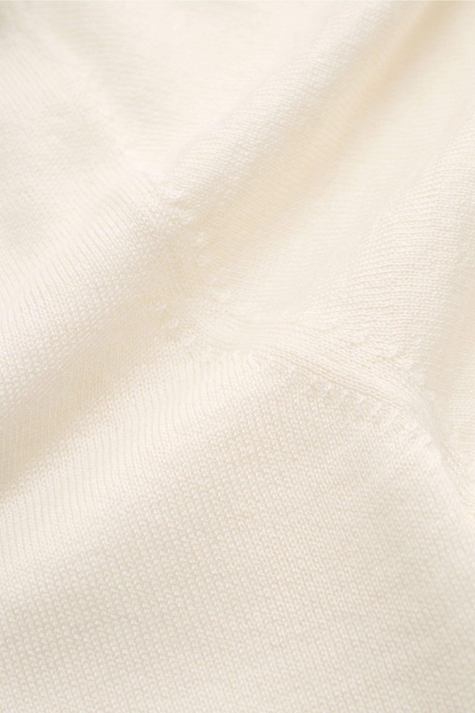 Nahaufnahme des FTC Kurzarm-Strickpolo creme aus feinstem Cashmere-SeaCell-Mix, feines Strickbild, leichte Qualität, nachhaltige Produktion.