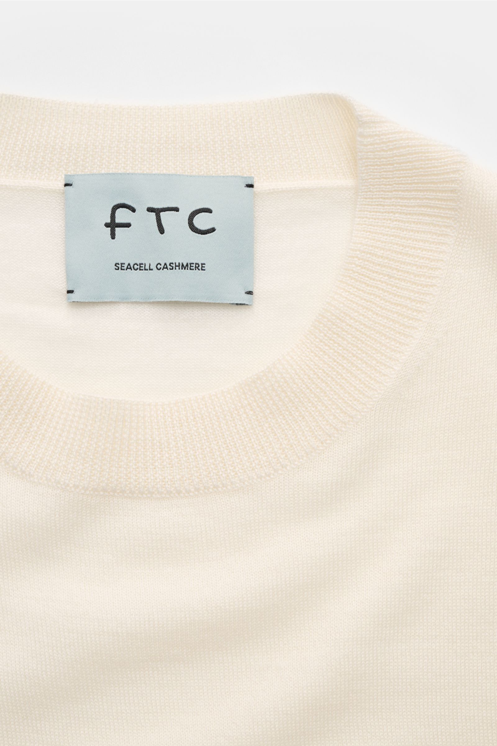 Nahaufnahme von FTC Kurzarm-Rundhalspullover creme, Slim Fit mit rundem Ausschnitt, feinem Strickbild, rolliertem Saum, nachhaltigem Cashmere-SeaCell-Mix.