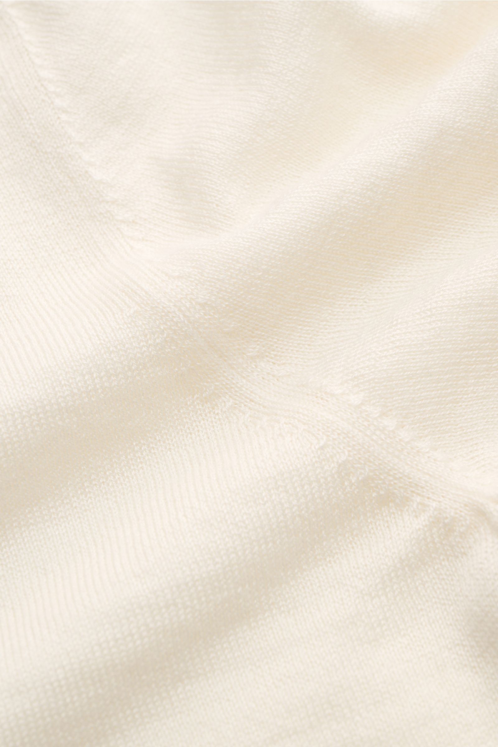 Nahaufnahme des cremefarbenen FTC Kurzarm-Rundhalspullovers aus nachhaltigem Cashmere-SeaCell-Mix mit feinem Strickbild und rolliertem Saum.