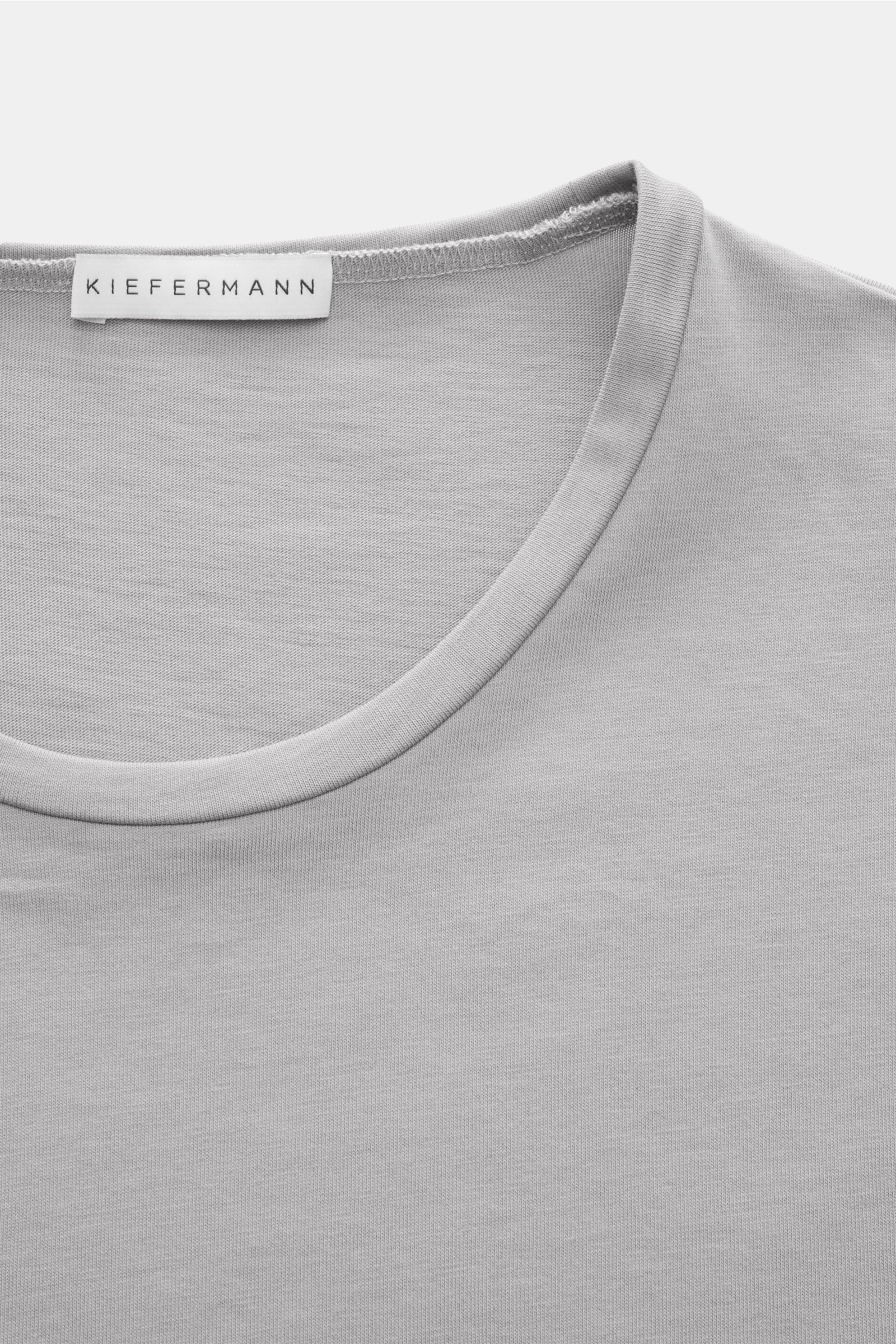 Nahaufnahme des Kiefermann Rundhals T-Shirts 'Matello' grau, körpernah geschnitten aus weichem Baumwoll-Jersey mit Rundhalsausschnitt und Logodruck am Saum.