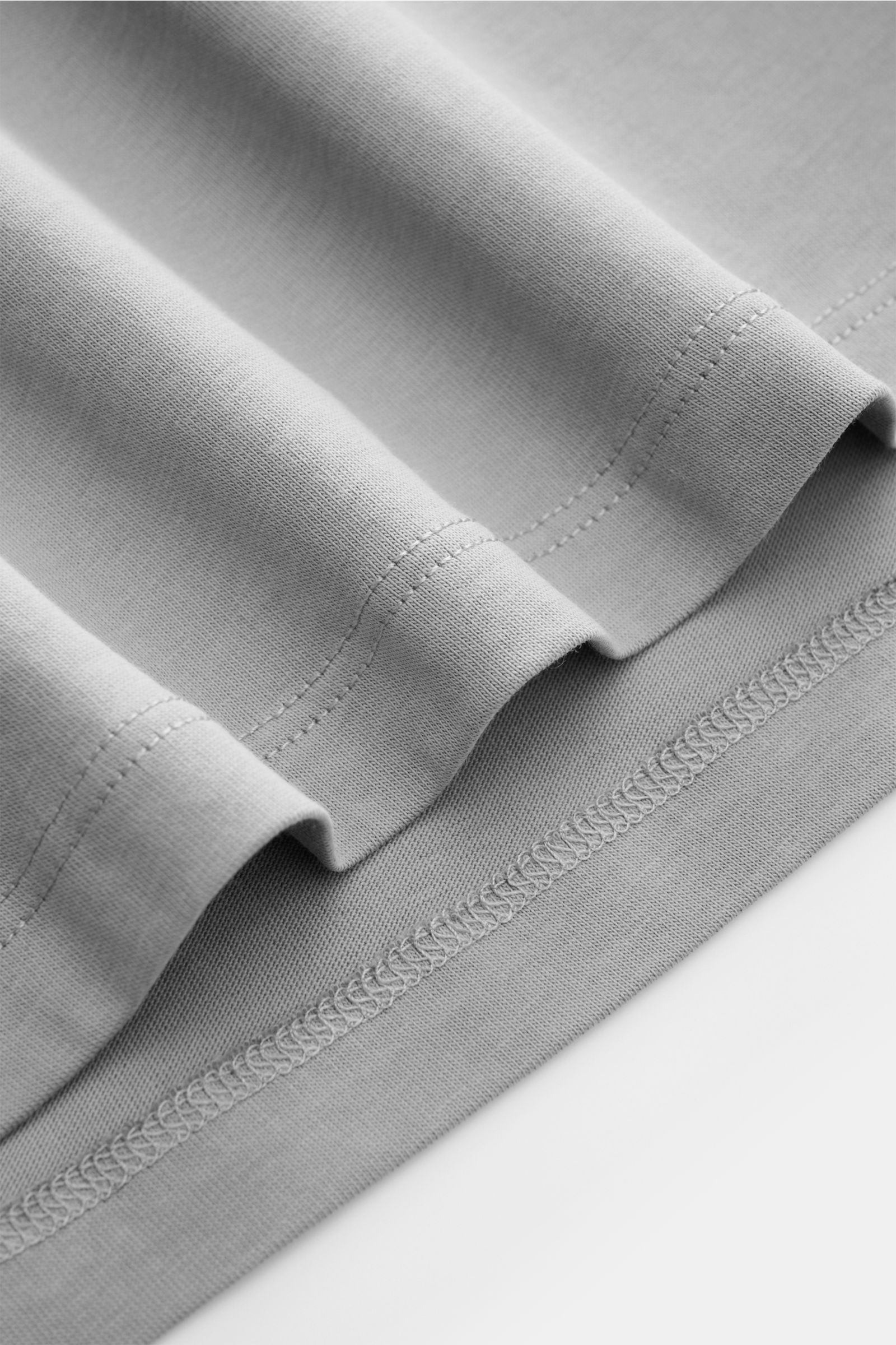 Nahaufnahme des grauen Kiefermann Rundhals T-Shirts 'Matello' von unten, Jersey-Baumwolle, weicher Griff, Extra Slim Fit, Rundhalsausschnitt, dezenter Logodruck am Saum.