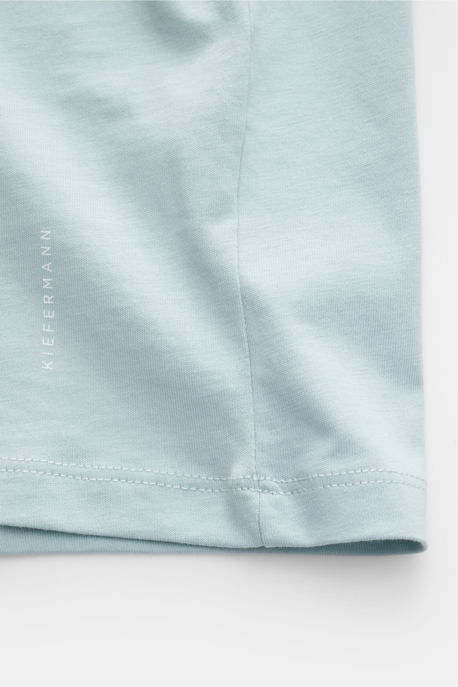 Kiefermann Rundhals T-Shirt 'Matello' hellblau, Detailfoto vom Saum mit dezentem Logodruck, Jersey aus Baumwolle, Extra Slim Fit, weicher Griff.