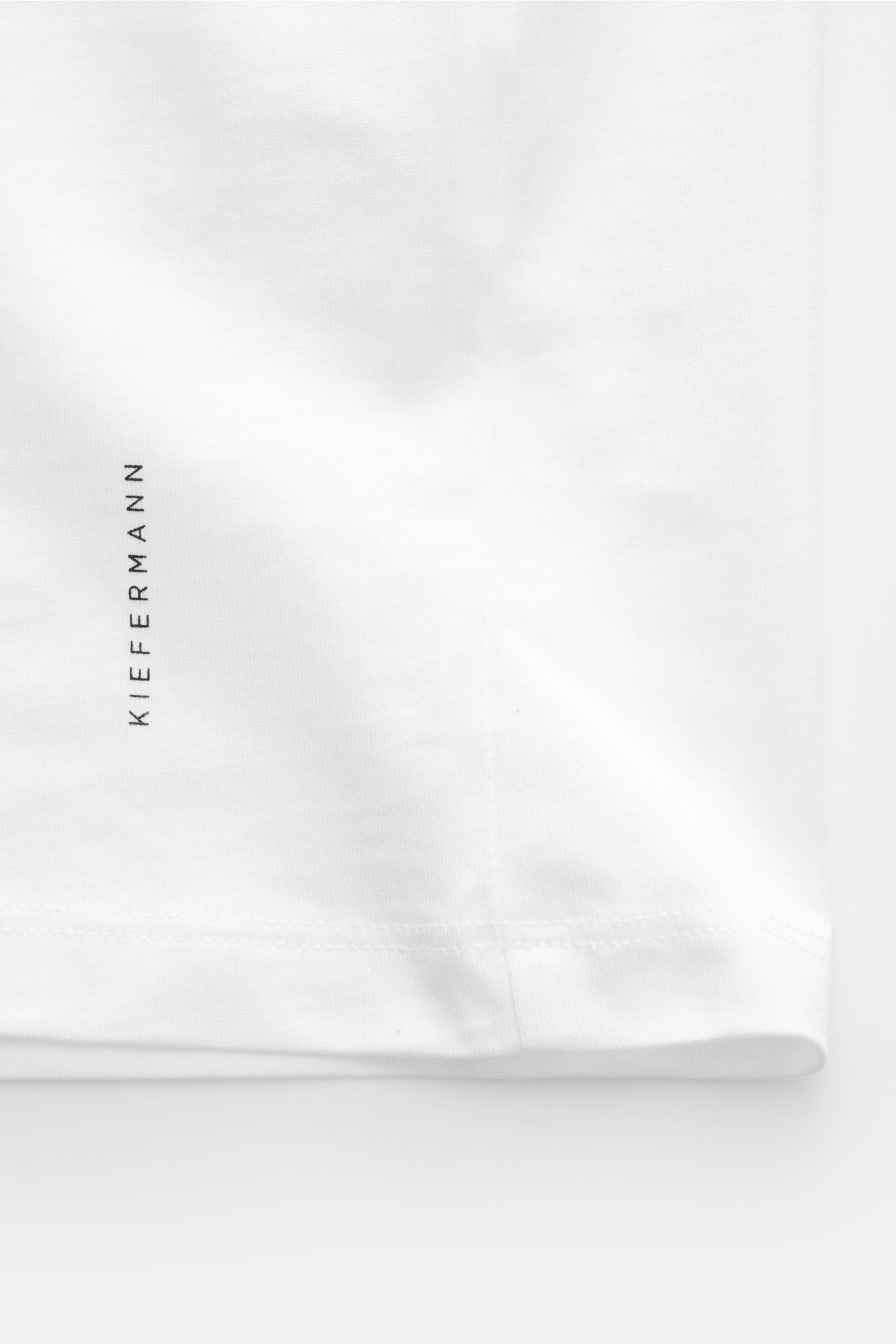 Kiefermann Rundhals T-Shirt 'Matello' weiß, Detailaufnahme vom Saum mit dezentem Logodruck, Jersey aus Baumwolle, weicher Griff, Extra Slim Fit.