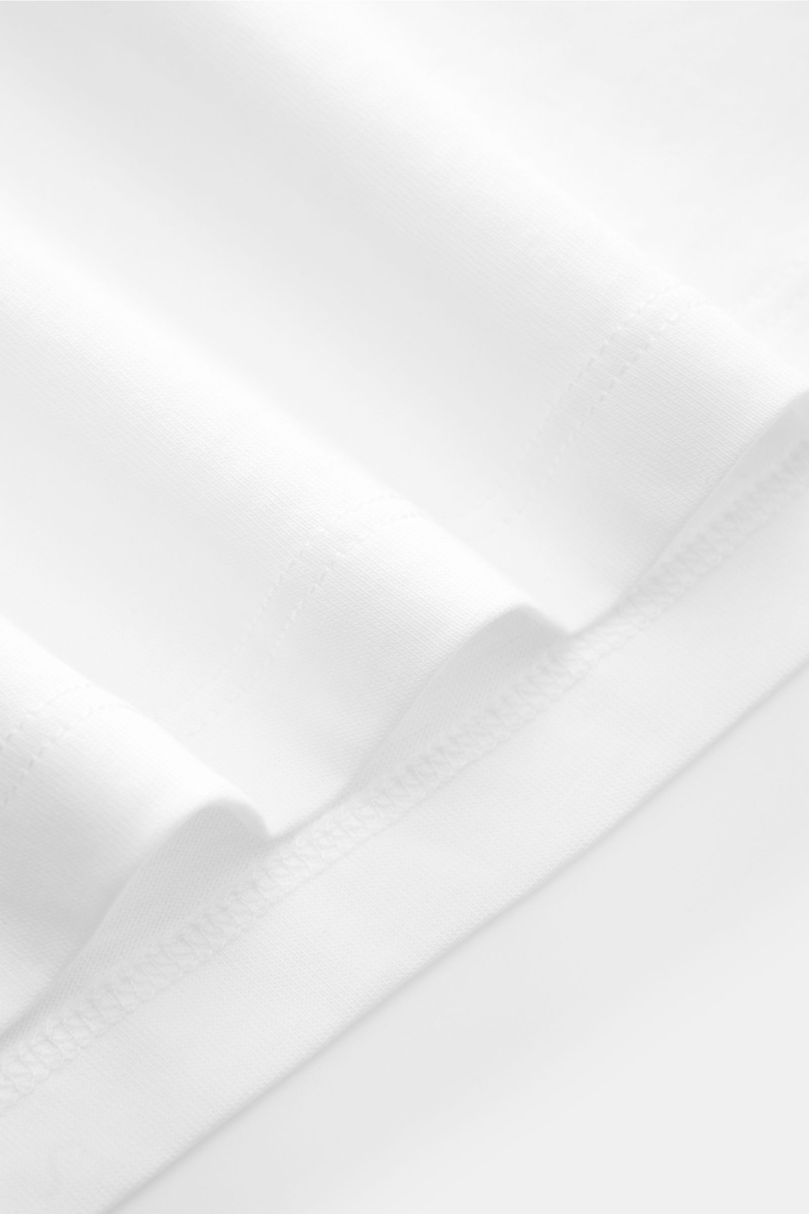 Nahaufnahme des Kiefermann Rundhals T-Shirts 'Matello' weiß, Jersey aus Baumwolle, weicher Griff, Extra Slim Fit, Rundhalsausschnitt, dezenter Logodruck am Saum.