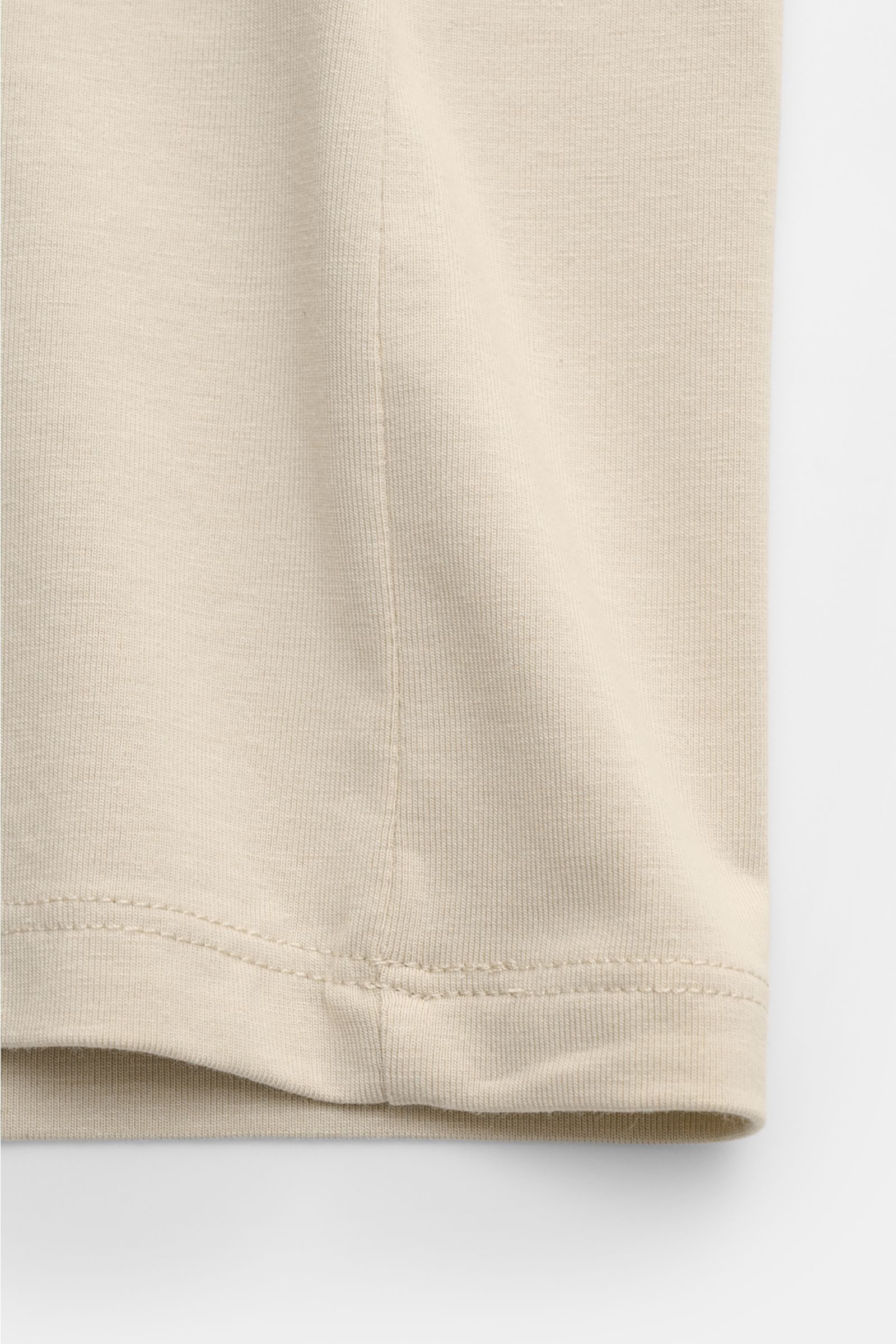 Nahaufnahme des unteren Saums vom Kiefermann V-Neck T-Shirt 'Hape' sand, gefertigt aus elastischem Baumwoll-Modal-Jersey mit weichem, glattem Griff, Extra Slim Fit, V-Ausschnitt, fotografiert von der Seitennaht aus.