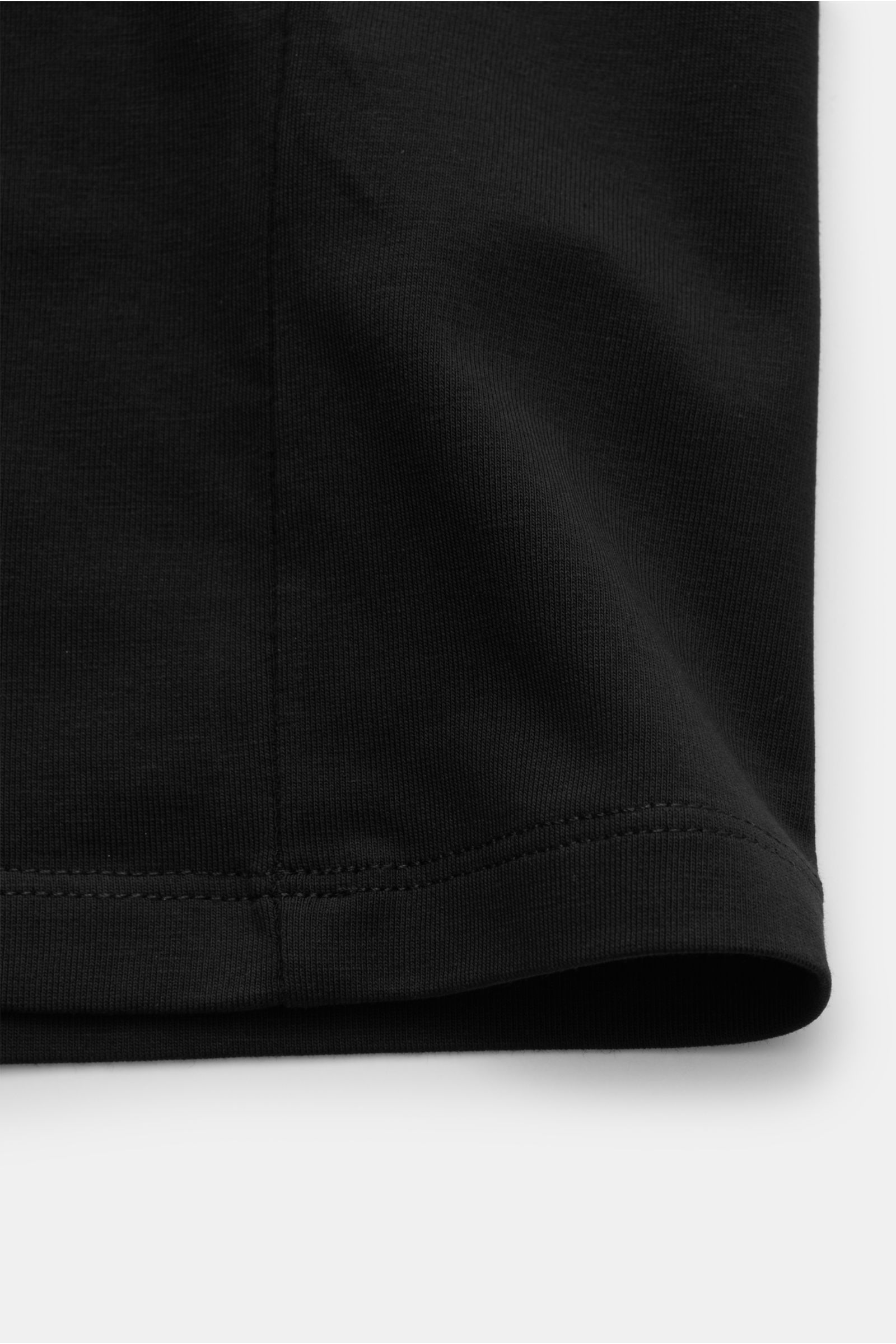 Close-up front view of the hem and side seam of the Kiefermann Crew neck T-shirt 'Lehon' black, made of soft cotton with elasticated fabric, soft feel, extra slim fit, and crew neck.