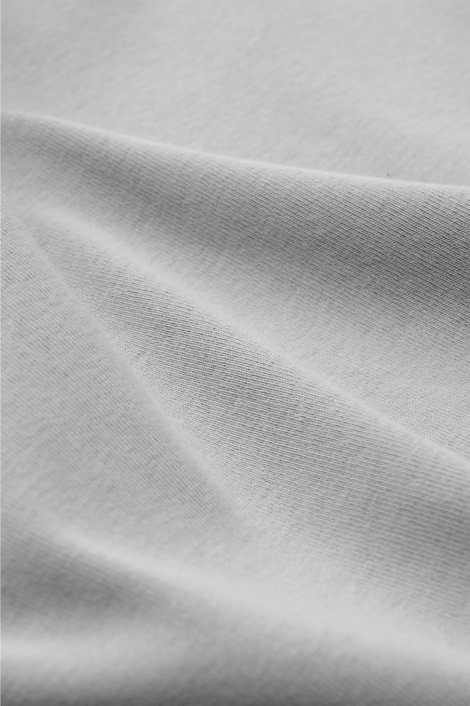 Nahaufnahme des grauen Kiefermann Rundhals-T-Shirts 'Paddys', zeigt weichen, elastischen Baumwollstoff mit feiner Struktur und leichter Faltenbildung, fotografiert aus schräger Perspektive, Slim Fit, Rundhalsausschnitt, angenehmer Griff, Understatement-Ba