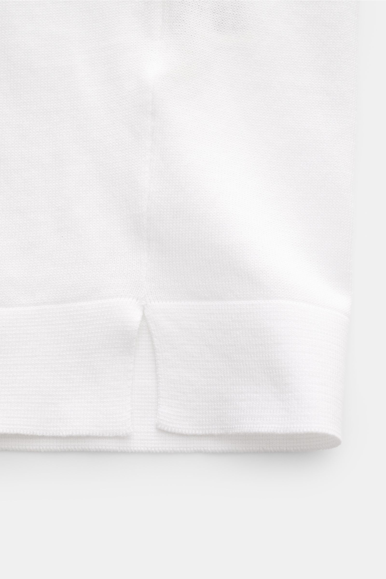Close-up front view of the hem with side slit of the Filippo de Laurentiis Feinstrick-Kurzarmpullover weiß, a slim fit white short-sleeve fine knit pullover made of pure cotton with soft touch, round neckline, comfortable cuffs, and very fine knit texture