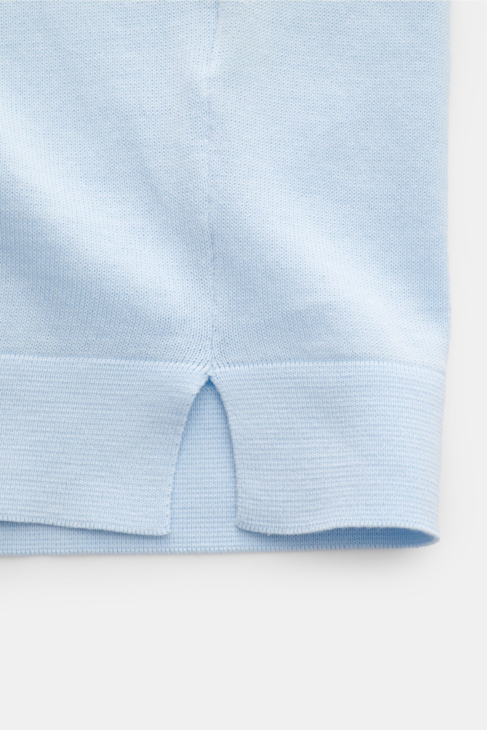 Close-up front view of the hem with side slit of the Filippo de Laurentiis Feinstrick-Kurzarmpullover hellblau, a slim fit, light blue short-sleeve fine knit cotton pullover with soft texture, round neckline, comfortable cuffs, and very fine knit pattern.