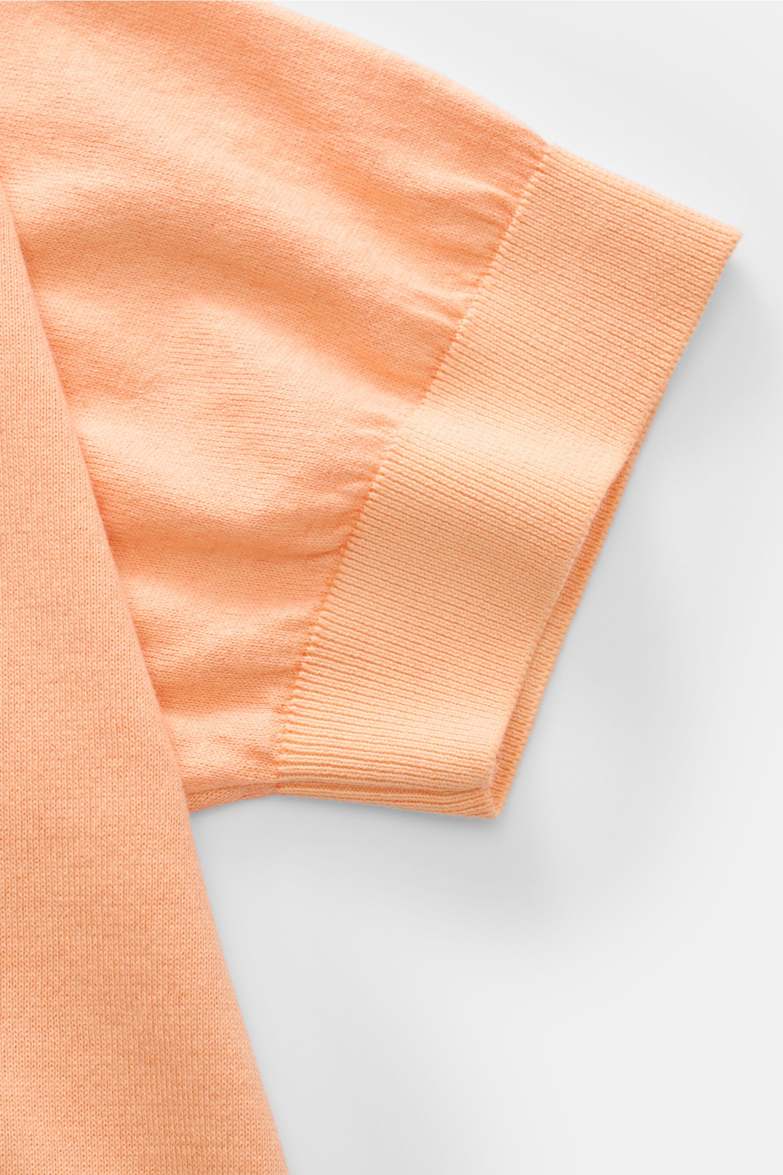 Close-up side view of the Filippo de Laurentiis Kurzarmpullover apricot short sleeve, showing pure cotton fabric, soft texture, fine knit, slim fit, round neckline, and comfortable ribbed cuffs. Vielseitiges Basic: Der Kurzarmpullover von FILIPPO DE LAURE