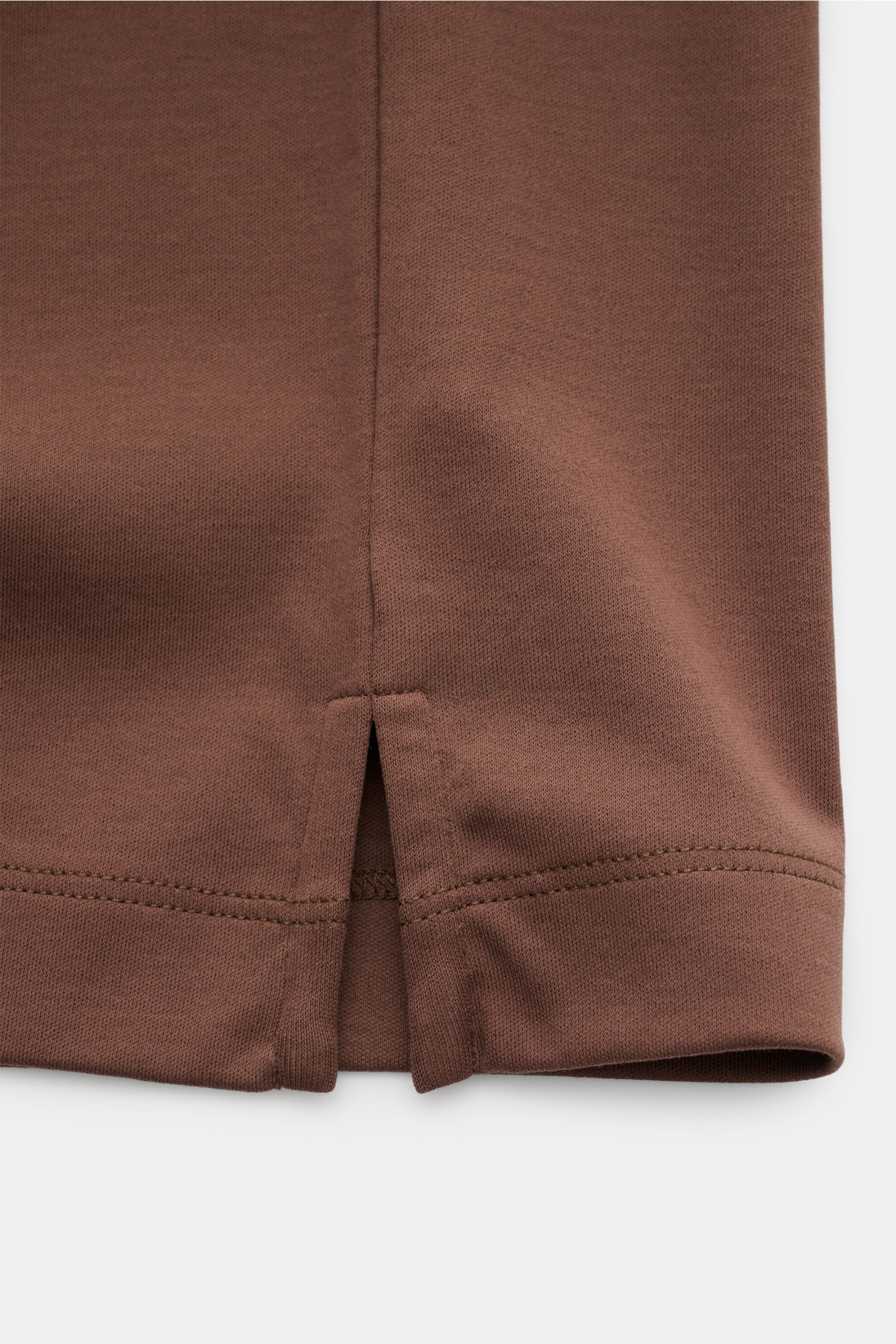 Nahaufnahme der kurzen Saumschlitze am Aurélien Rundhals-T-Shirt braun aus ägyptischer Baumwolle, Slim Fit, weicher Griff, Rundhalsausschnitt, dezentes Logo-Stitching auf der Rückseite, fotografiert von unten.