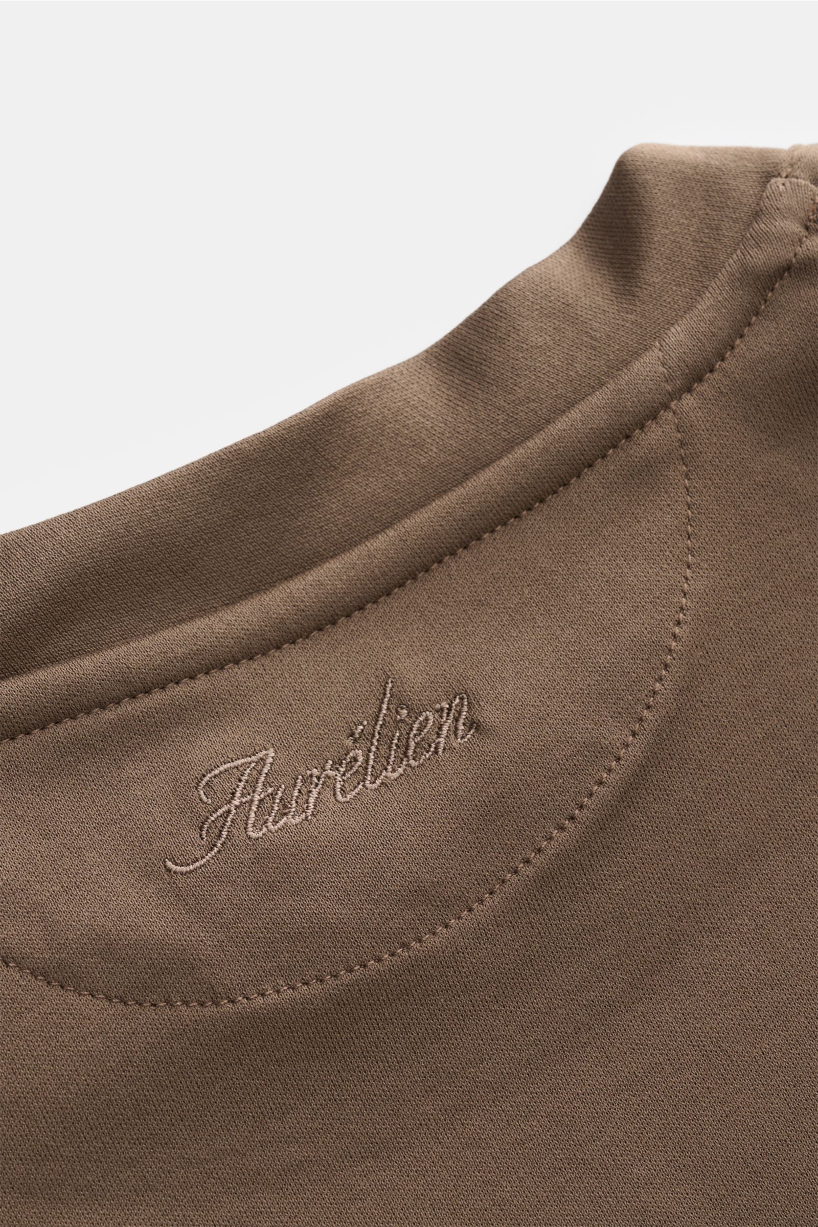 Close-up image of the back neckline of the Aurélien Rundhals-T-Shirt khaki, showing the subtle logo stitching, photographed from a top-down perspective; jersey aus ägyptischer Baumwolle, weicher, glatter Griff, Slim Fit, Rundhalsausschnitt, kurze Saumschl