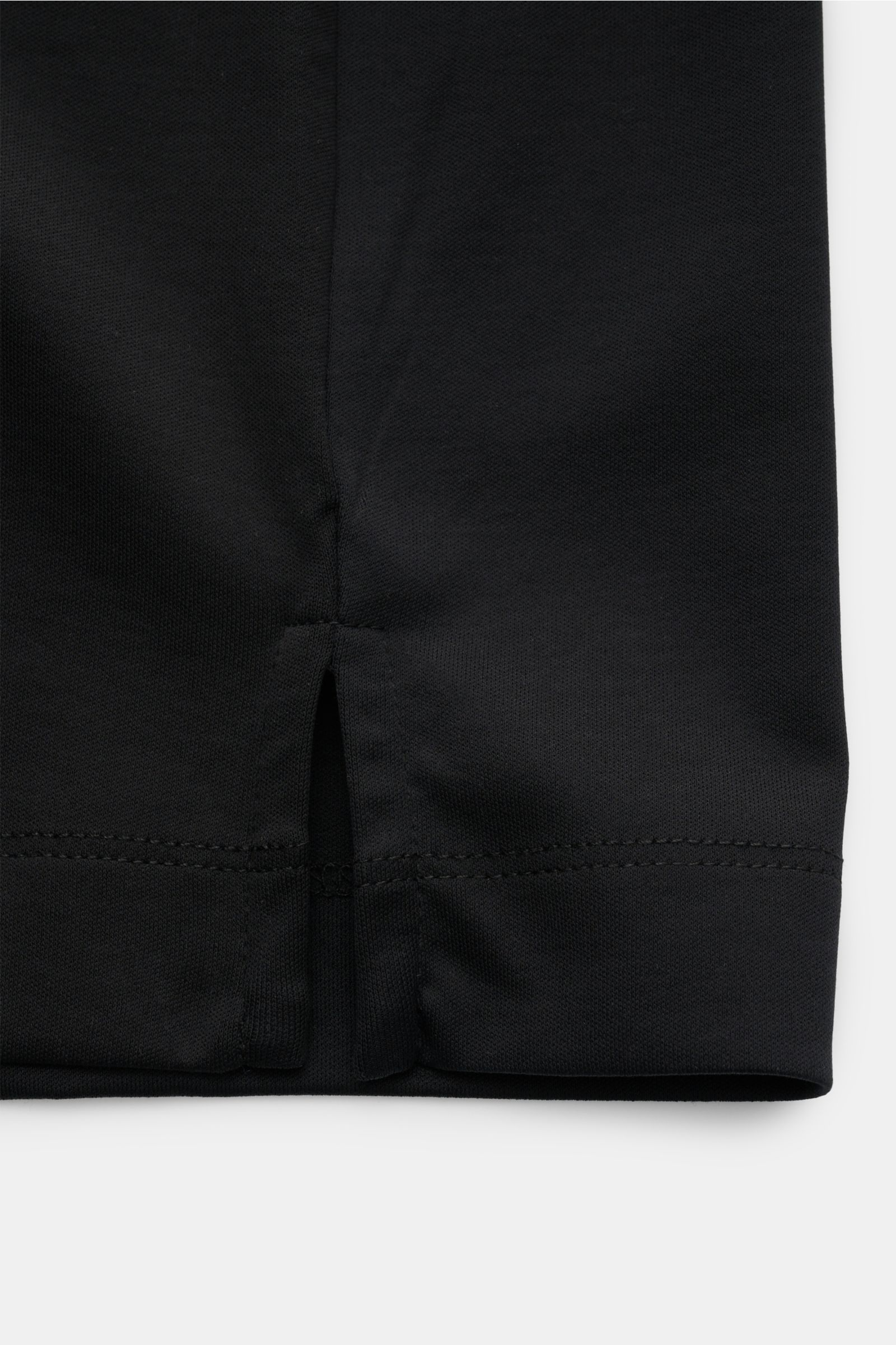 Detailaufnahme des unteren Saums mit kurzen Saumschlitzen des Aurélien Rundhals-T-Shirt schwarz aus ägyptischer Baumwolle, Slim Fit, weichem, glattem Griff und dezentem Logo-Stitching auf der Rückseite.