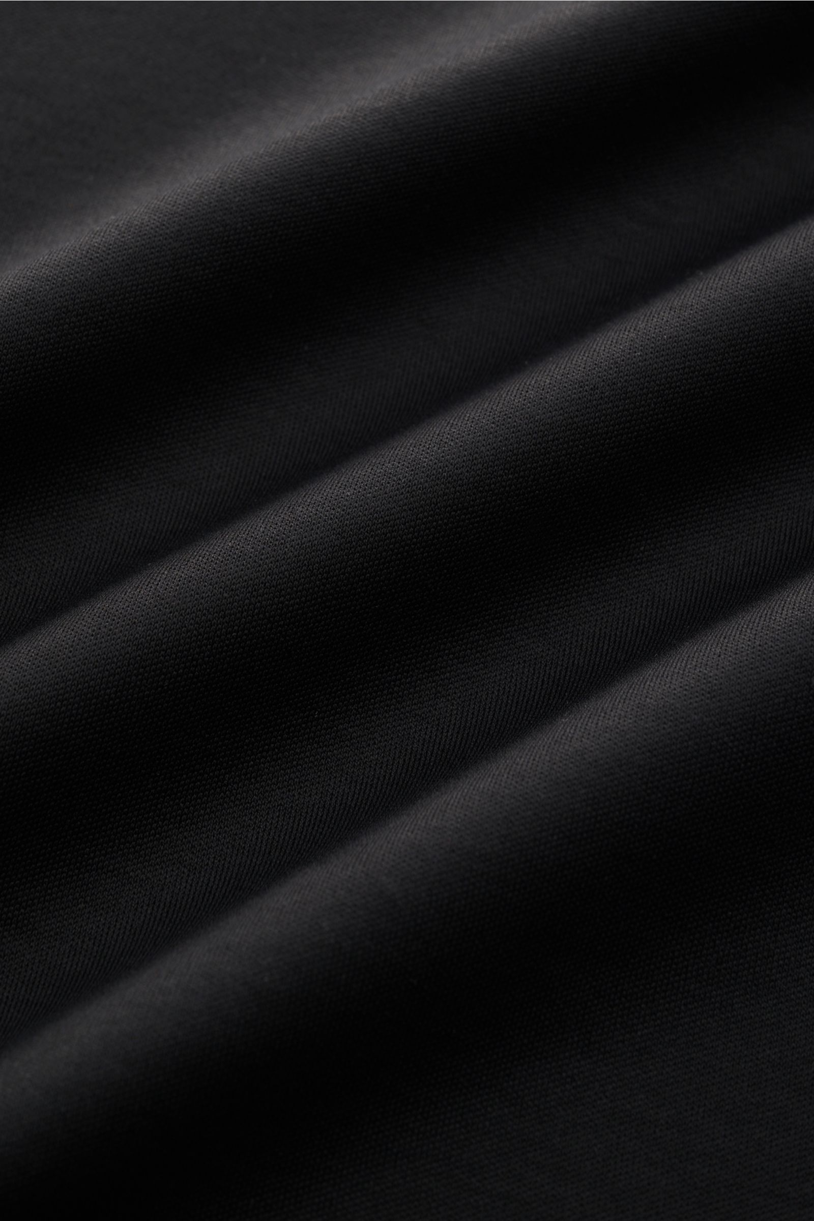 Aurélien Rundhals-T-Shirt schwarz, Nahaufnahme des weichen Jersey-Stoffs aus ägyptischer Baumwolle mit glattem Griff, Slim Fit, Rundhalsausschnitt, kurzen Saumschlitzen und dezenter Logo-Stitching auf der Rückseite.