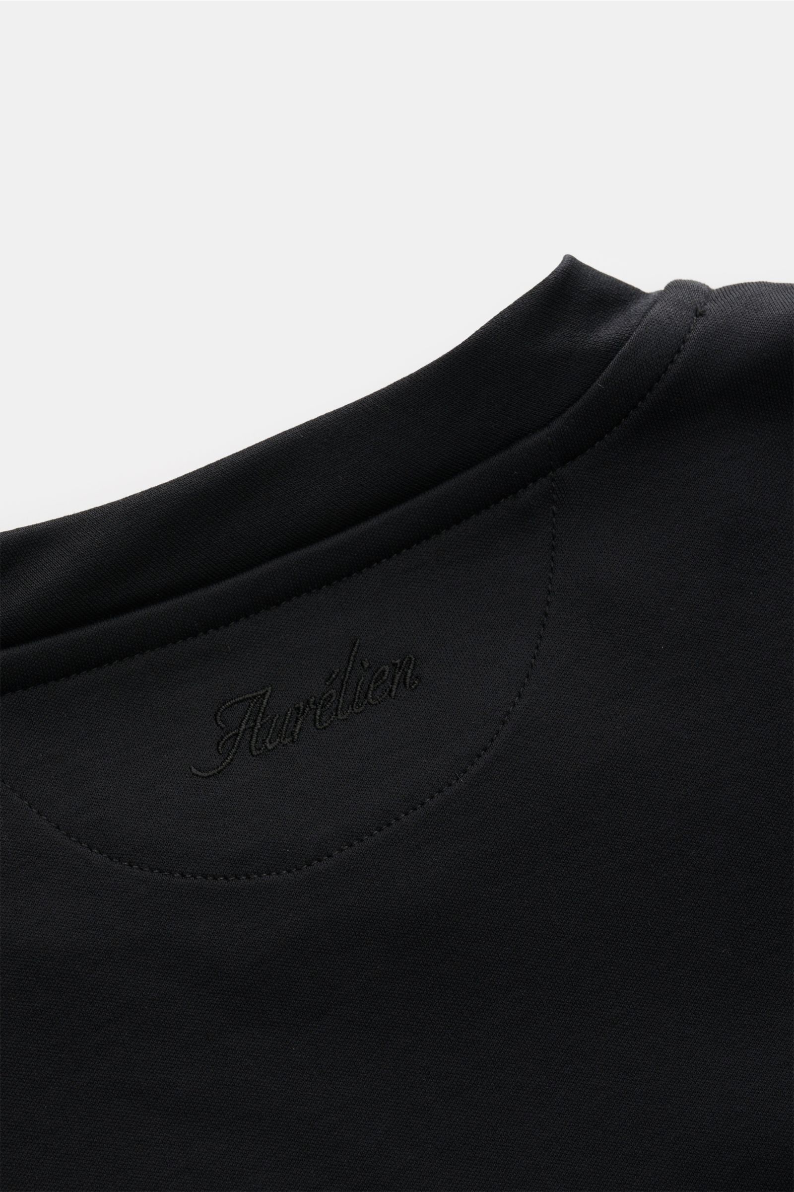 Aurélien Rundhals-T-Shirt schwarz, Detailansicht von oben, Jersey aus ägyptischer Baumwolle, weicher Griff, Slim Fit, Rundhalsausschnitt, kurze Saumschlitze, dezentes Logo-Stitching auf Rückseite.