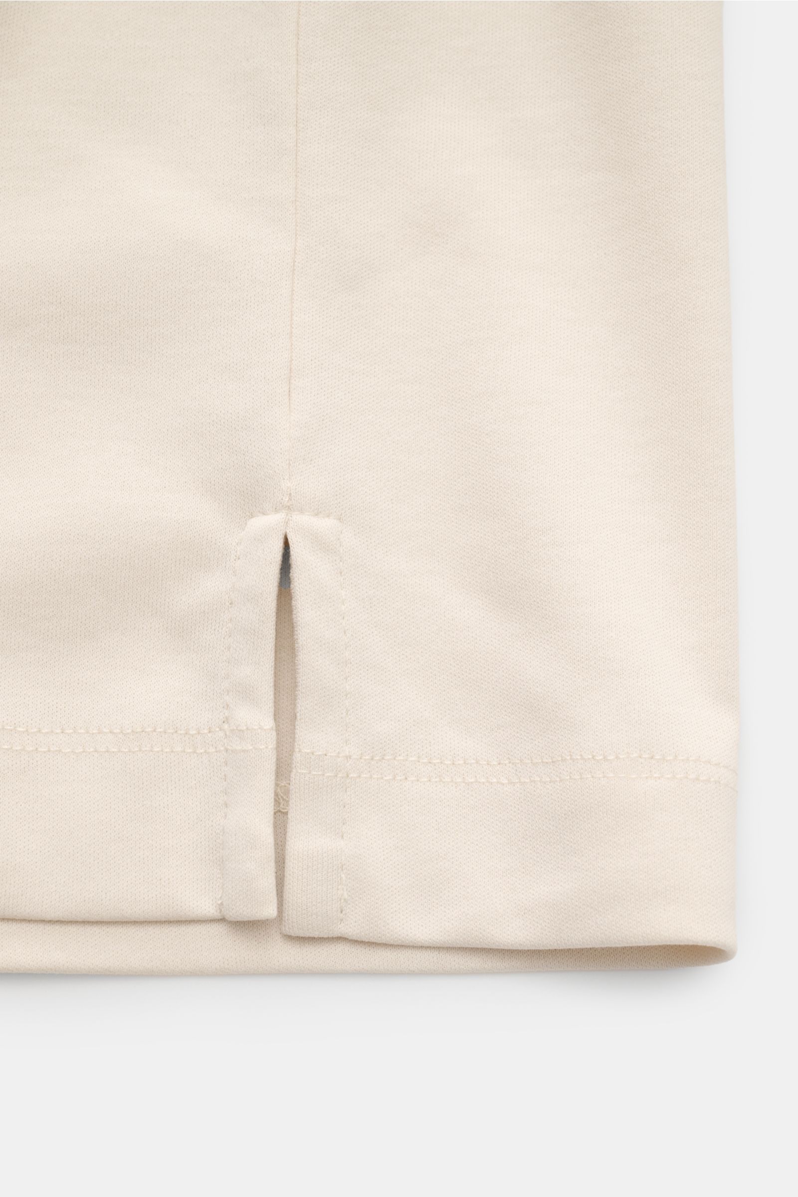 Close-up view of the hem with short side slits of the Aurélien Rundhals-T-Shirt sand, made of jersey from Egyptian cotton, with a soft, smooth feel, slim fit, round neckline, and subtle logo stitching on the back.