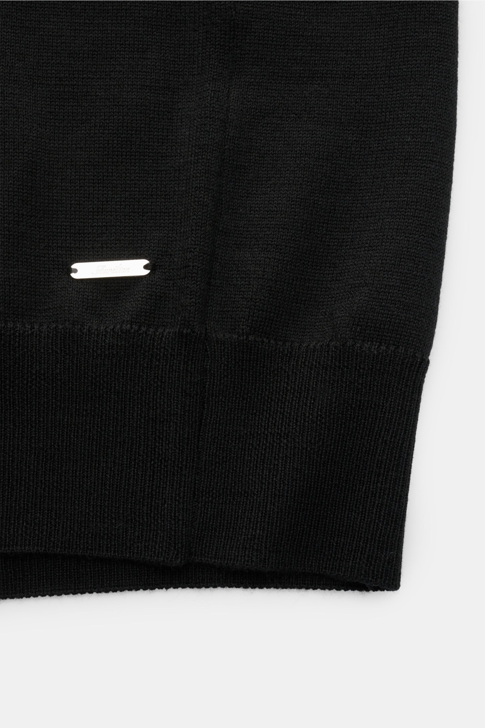 Nahaufnahme vom unteren Saum des Aurélien Merino Kurzarmpullover schwarz, Strick aus Merinowolle, weicher Griff, Slim Fit, Rundhalsausschnitt, Rippbündchen.
