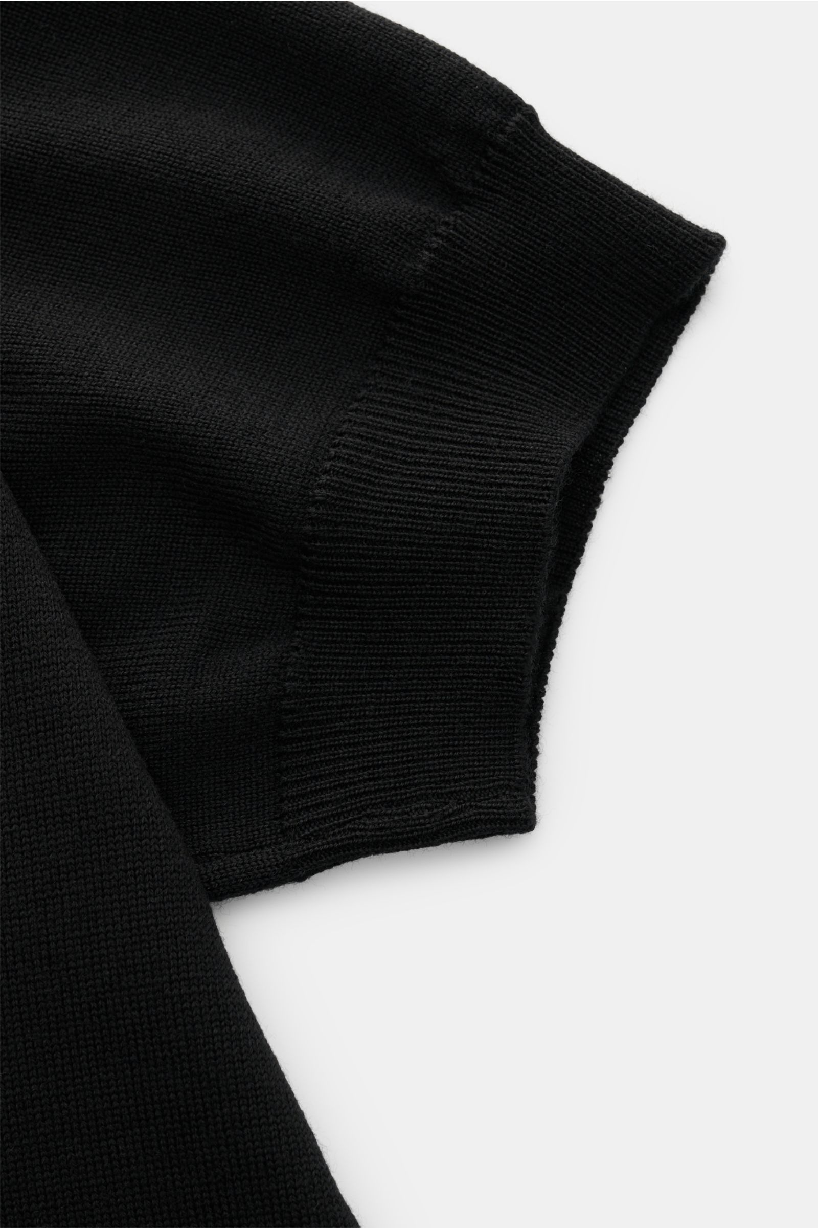 Nahaufnahme des Ärmelabschlusses vom Aurélien Merino Kurzarmpullover schwarz, Strick aus Merinowolle, weicher Griff, Slim Fit, Rundhalsausschnitt, Rippbündchen.