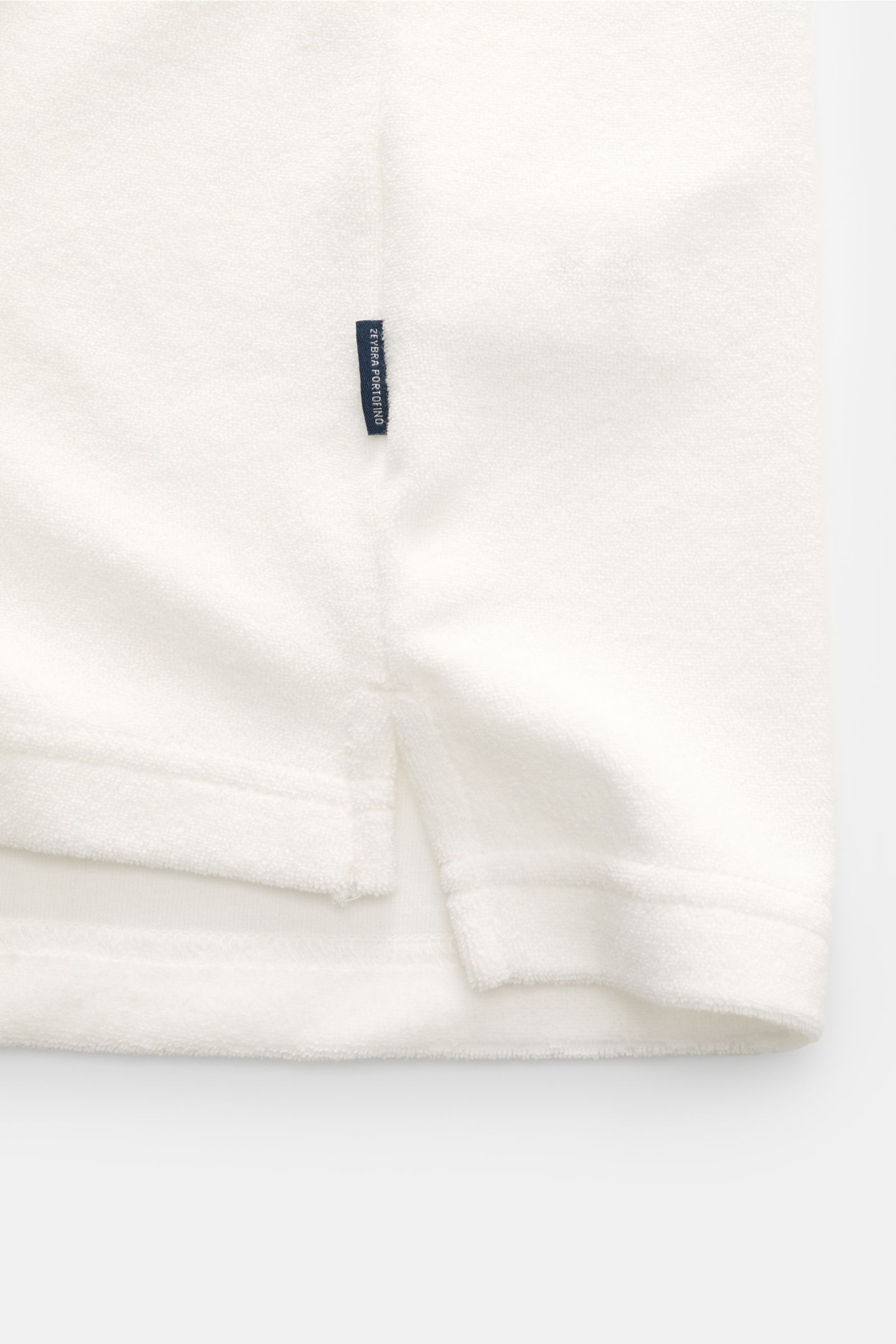 Zeybra Portofino 1962 Frottee Rundhals-T-Shirt 'Spugna' offwhite, Detailaufnahme der kurzen Saumschlitze und Weblabel, weiche Microfaser-Baumwolle.
