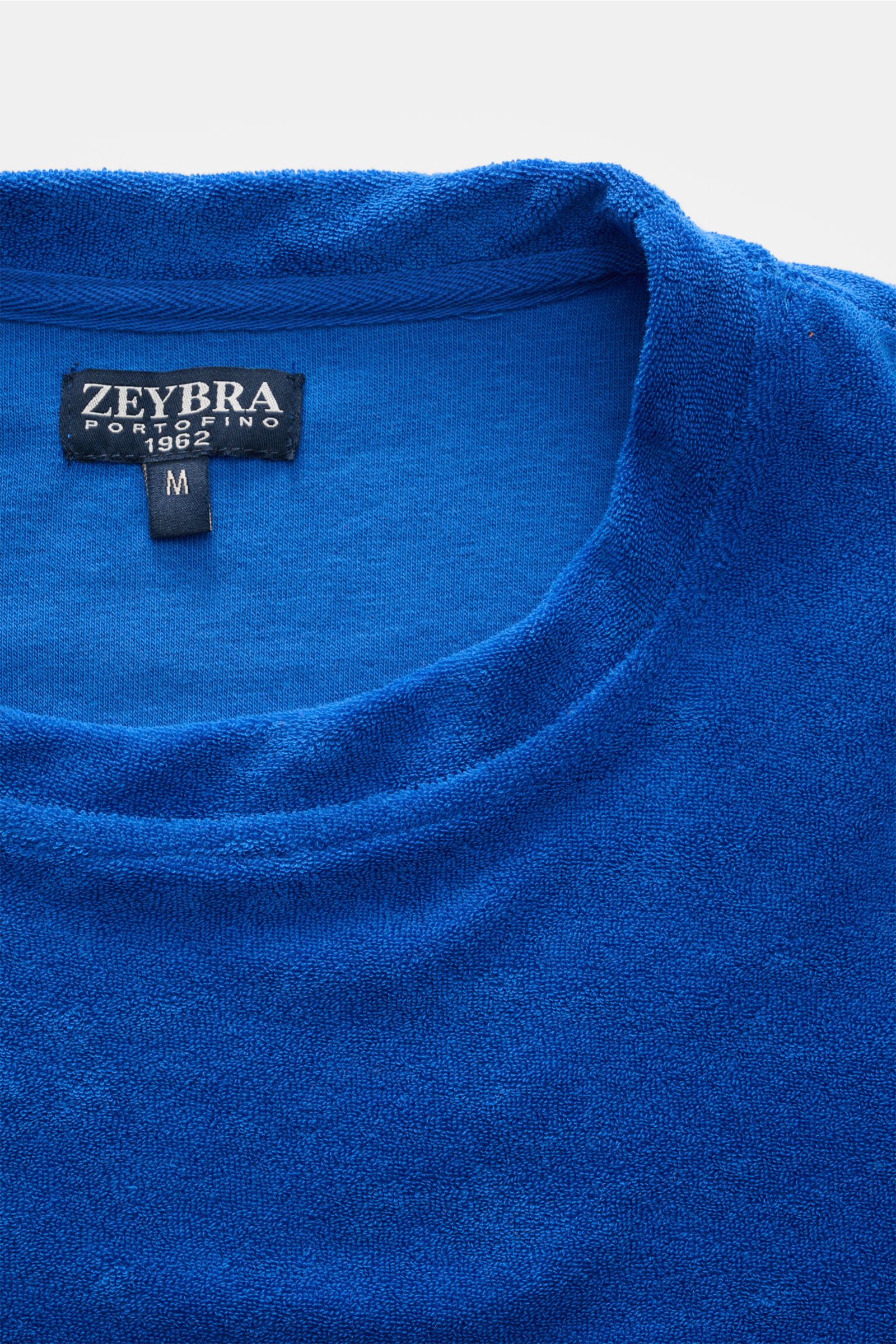 Nahaufnahme des Kragens von Zeybra Portofino 1962 Frottee Rundhals-T-Shirt 'Spugna' blau, weicher Microfaser-Baumwollstoff, Frottee-Struktur.