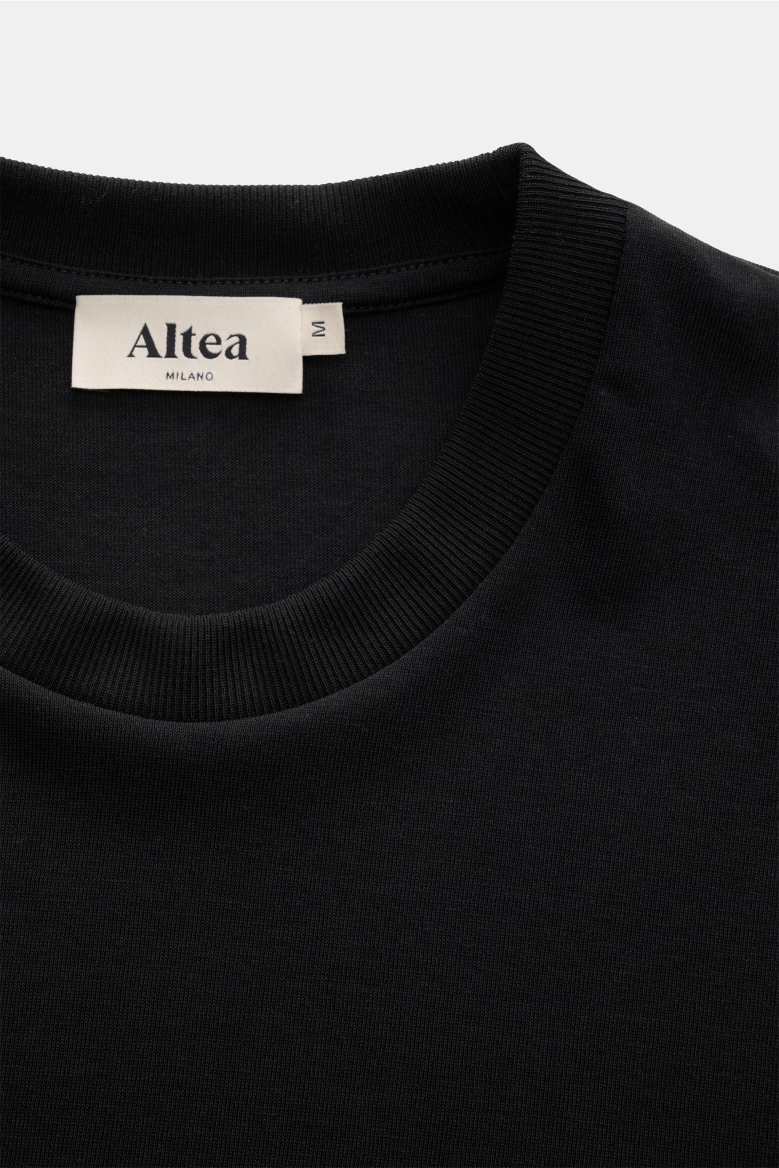Altea Short sleeve jumper 'Cecil' black shown from the top close-up of the neckline and label, made of soft lyocell-cotton blend.

For a summery feel: The airy short sleeve jumper 'Cecil' by ALTEA is made of a lightweight fine knit in a soft lyocell-co