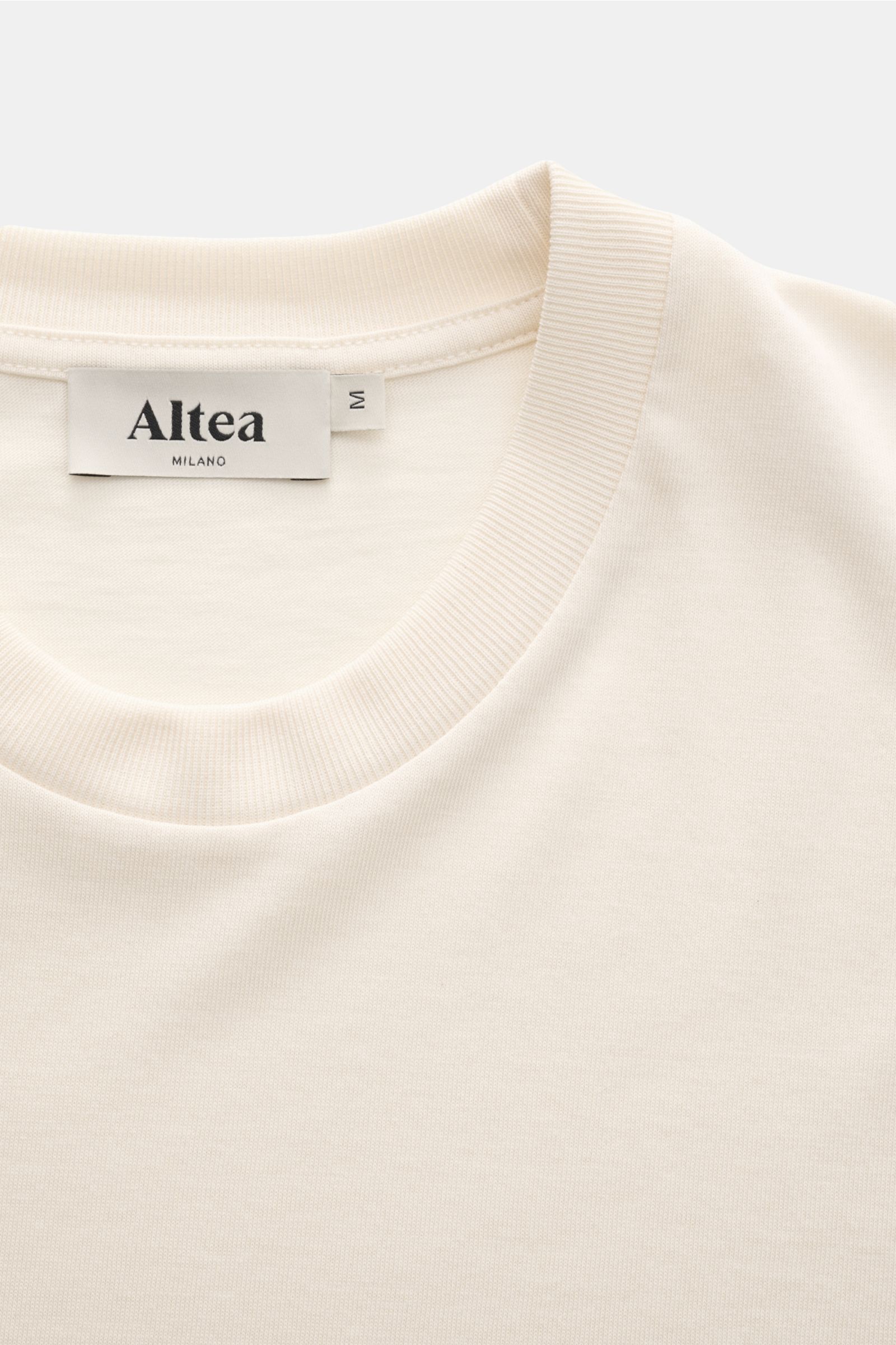Altea Short sleeve jumper 'Cecil' cream shown from a close-up top front perspective, featuring a soft lyocell-cotton blend, very fine knit, slim fit, elasticated ribbed bands, and short hem vents. For a summery feel: The airy short sleeve jumper 'Cecil' b