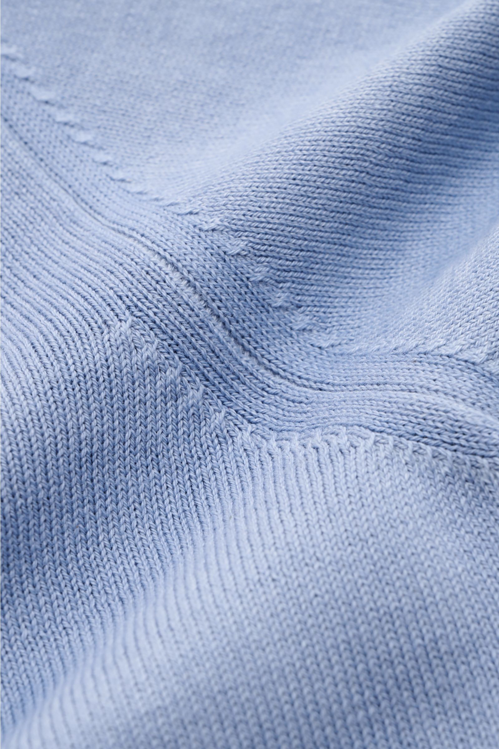 Nahaufnahme des Altea Kurzarmpullover rauchblau aus reiner Baumwolle, feines Strickbild, weicher Griff, Slim Fit, Rundhalsausschnitt, komfortable Rippbündchen, fotografiert aus schräger Perspektive.