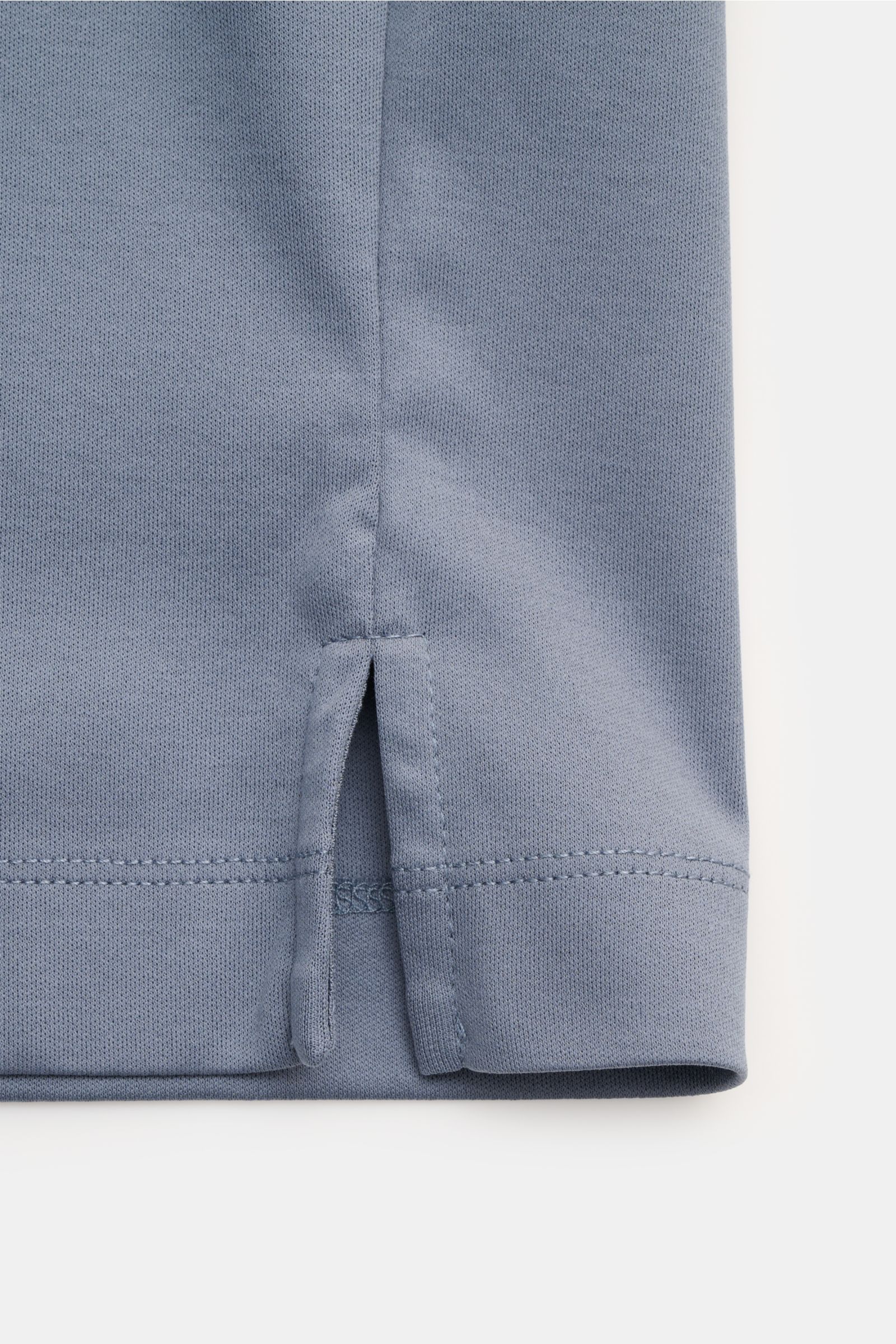 Nahaufnahme von kurzen Saumschlitzen des Aurélien Rundhals-T-Shirts rauchblau aus reiner Baumwolle, Slim Fit, weicher Griff, Frontansicht.