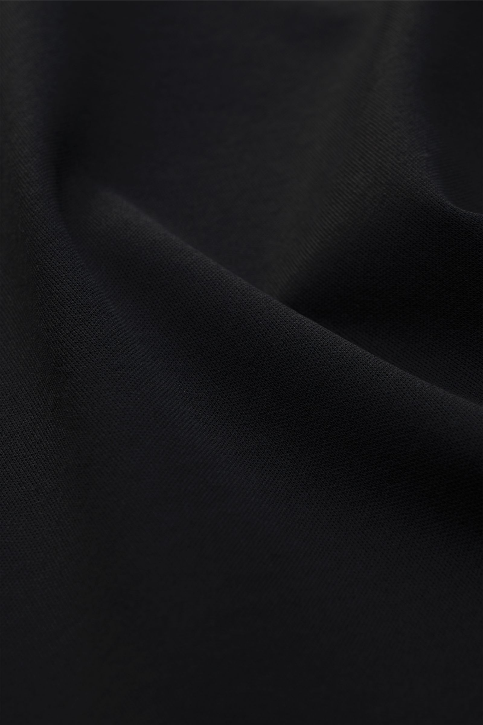 Aurélien Rundhals-T-Shirt schwarz aus reiner Baumwolle, weicher Griff, Slim Fit, Rundhalsausschnitt, kurze Saumschlitze, Detailaufnahme Stoffstruktur.