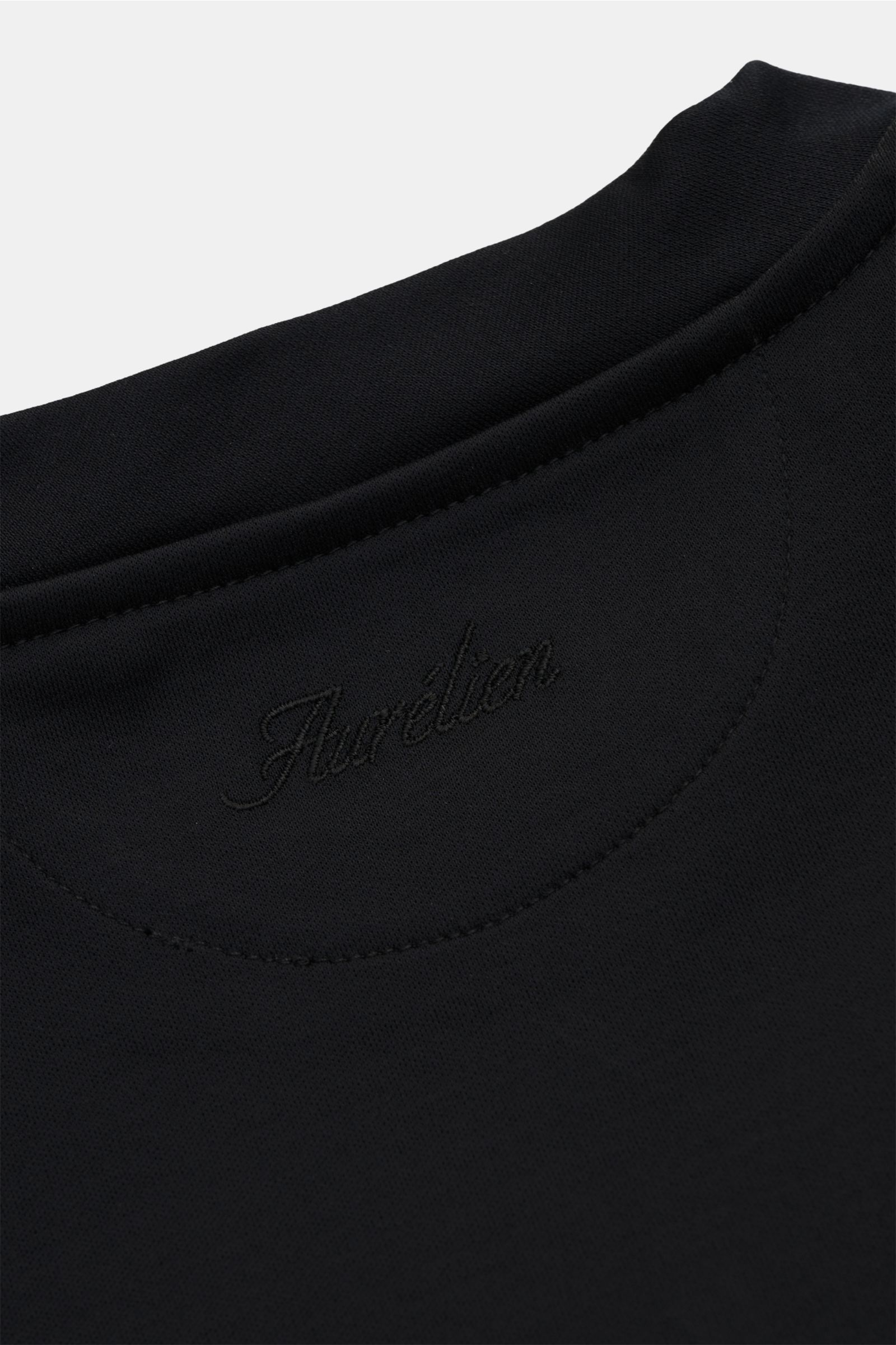 Nahaufnahme des schwarzen Aurélien Rundhals-T-Shirts mit Rundhalsausschnitt aus reiner Baumwolle, Slim Fit, weichem Griff und kurzen Saumschlitzen. Vielseitiges Basic für Frühling und Sommer.