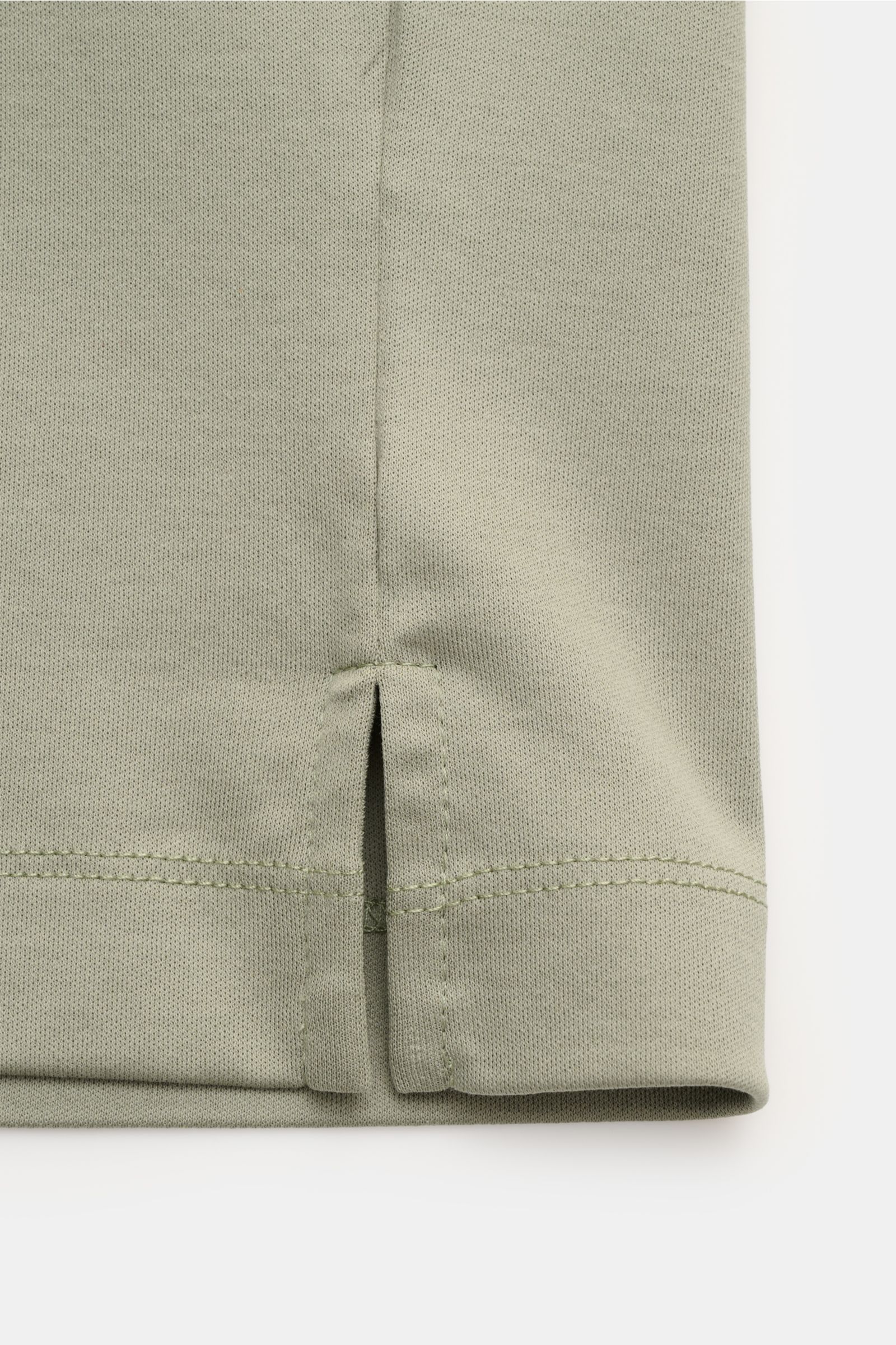 Nahaufnahme des Saumabschlusses mit kurzen Schlitzen des Aurélien Rundhals-T-Shirt salbei aus reiner Baumwolle, weicher Griff, Slim Fit, von unten fotografiert.
