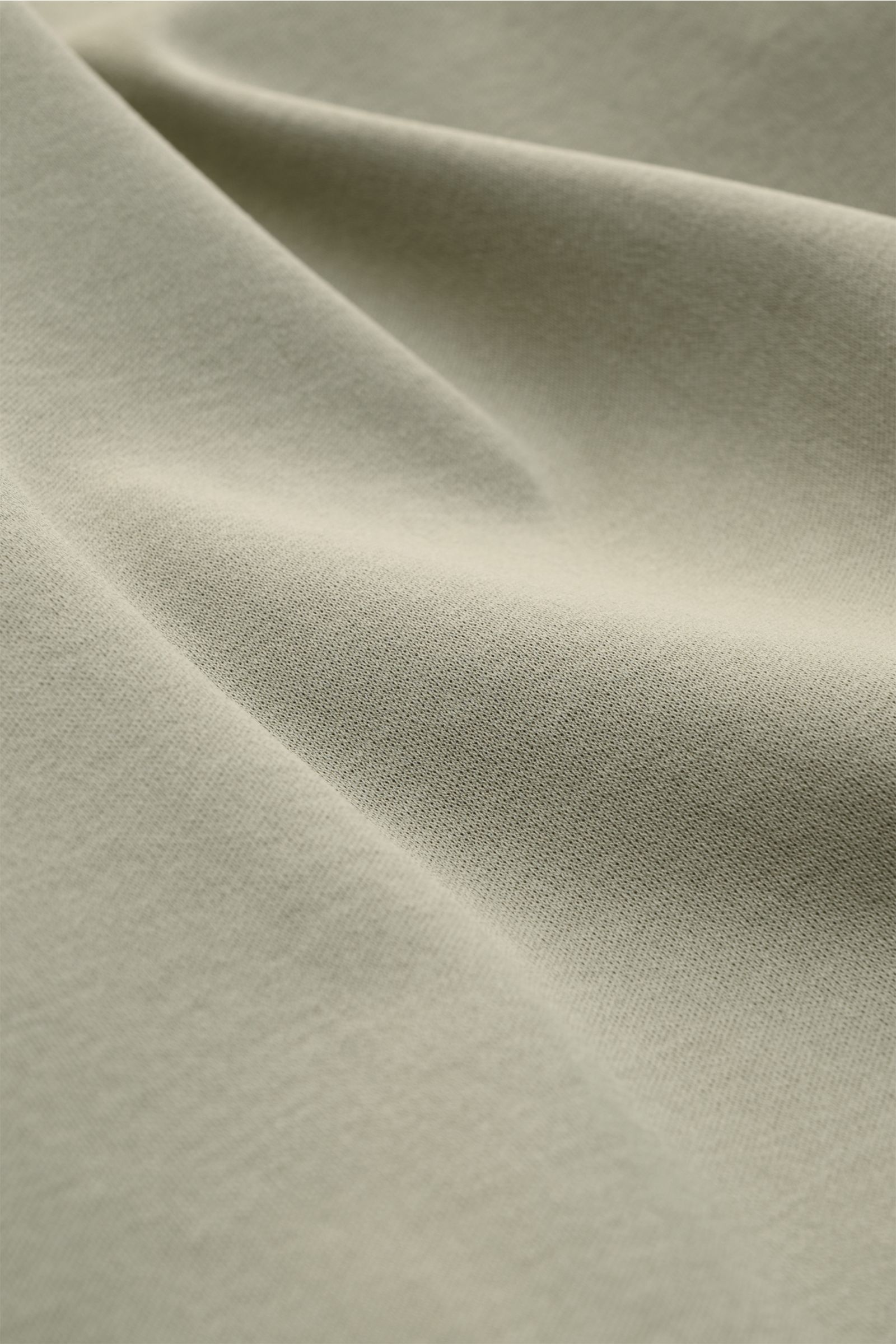 Nahaufnahme des weichen Stoffes vom Aurélien Rundhals-T-Shirt salbei in Slim Fit, reine Baumwolle, Rundhalsausschnitt, kurze Saumschlitze.