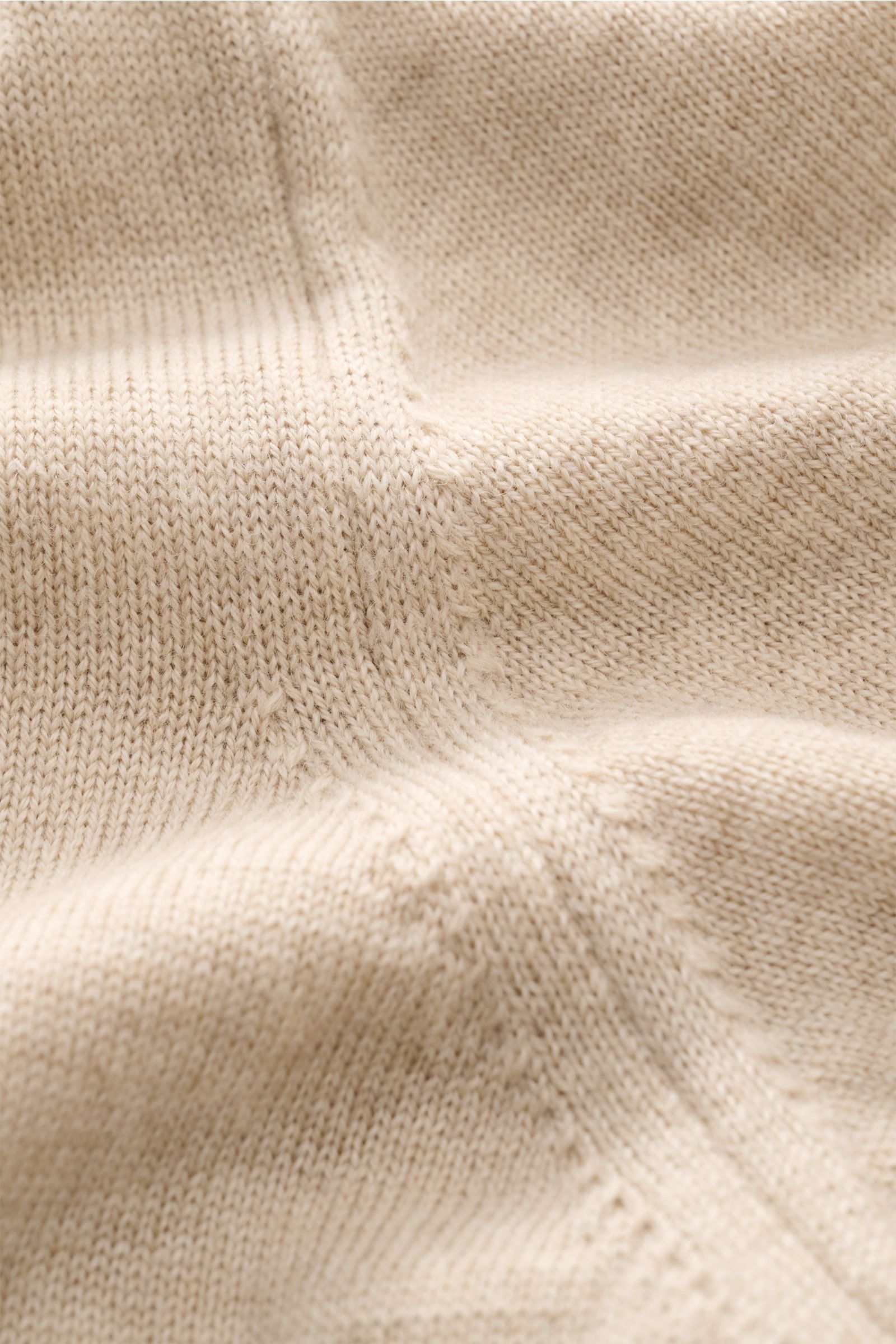 Close-up front view of Aurélien Short sleeve jumper 'Cashwool' beige mottled, showing fine knit pure merino wool, soft feel, crew neck, ribbed bands, and metal hem label.