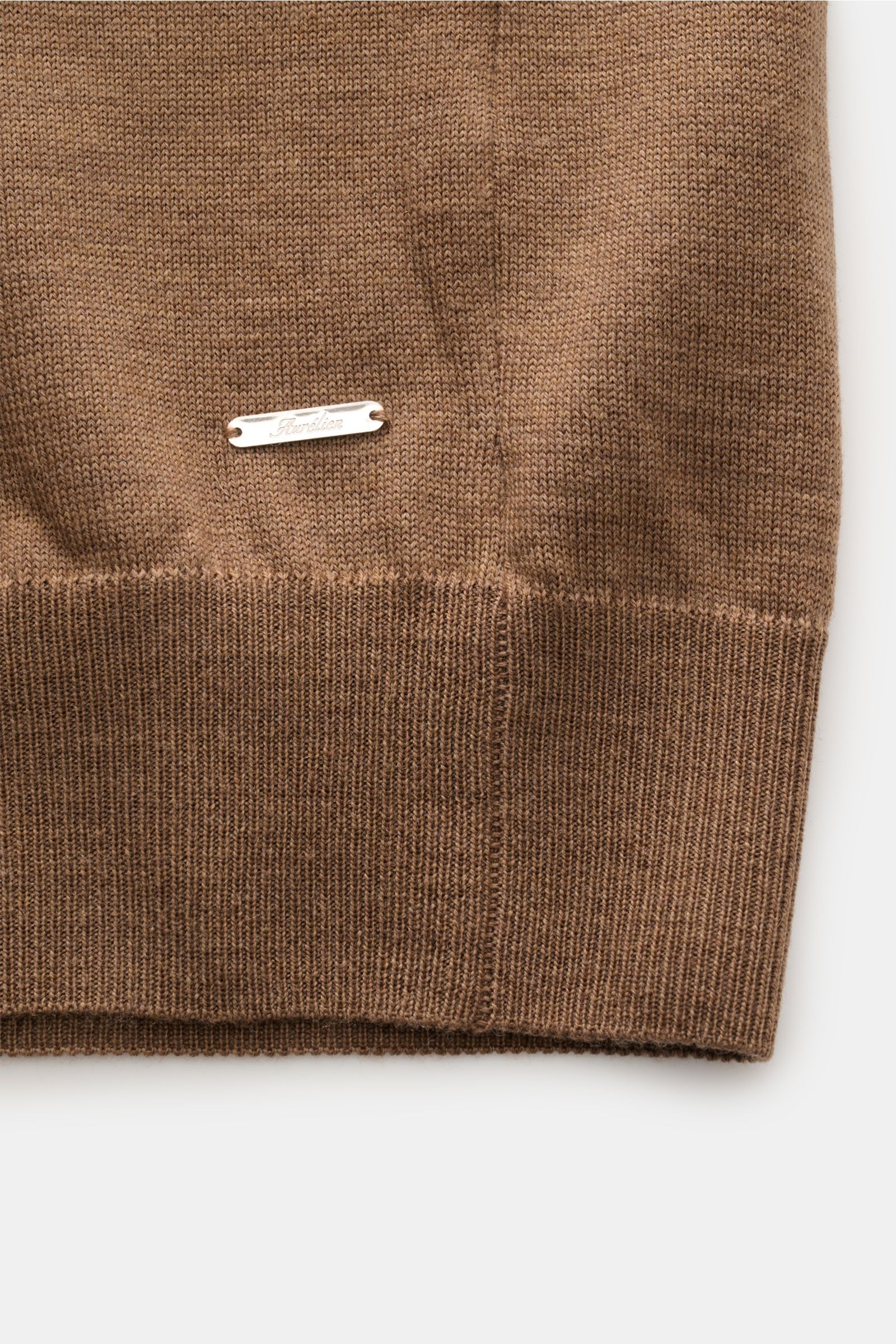 Close-up view from the front hem of the Aurélien Short sleeve jumper 'Cashwool' brown mottled showing fine-knit pure merino wool, ribbed bands, and metal label.