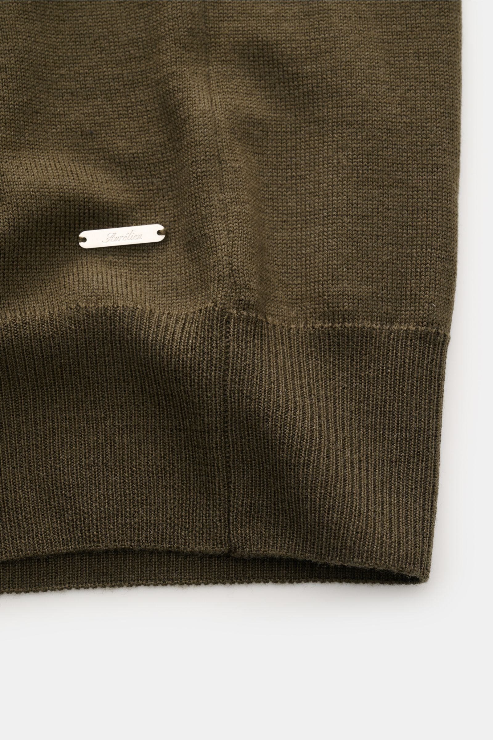 Close-up front view of Aurélien Short sleeve jumper 'Cashwool' dark olive hem, showcasing fine knit, ribbed bands, and metal label detail.