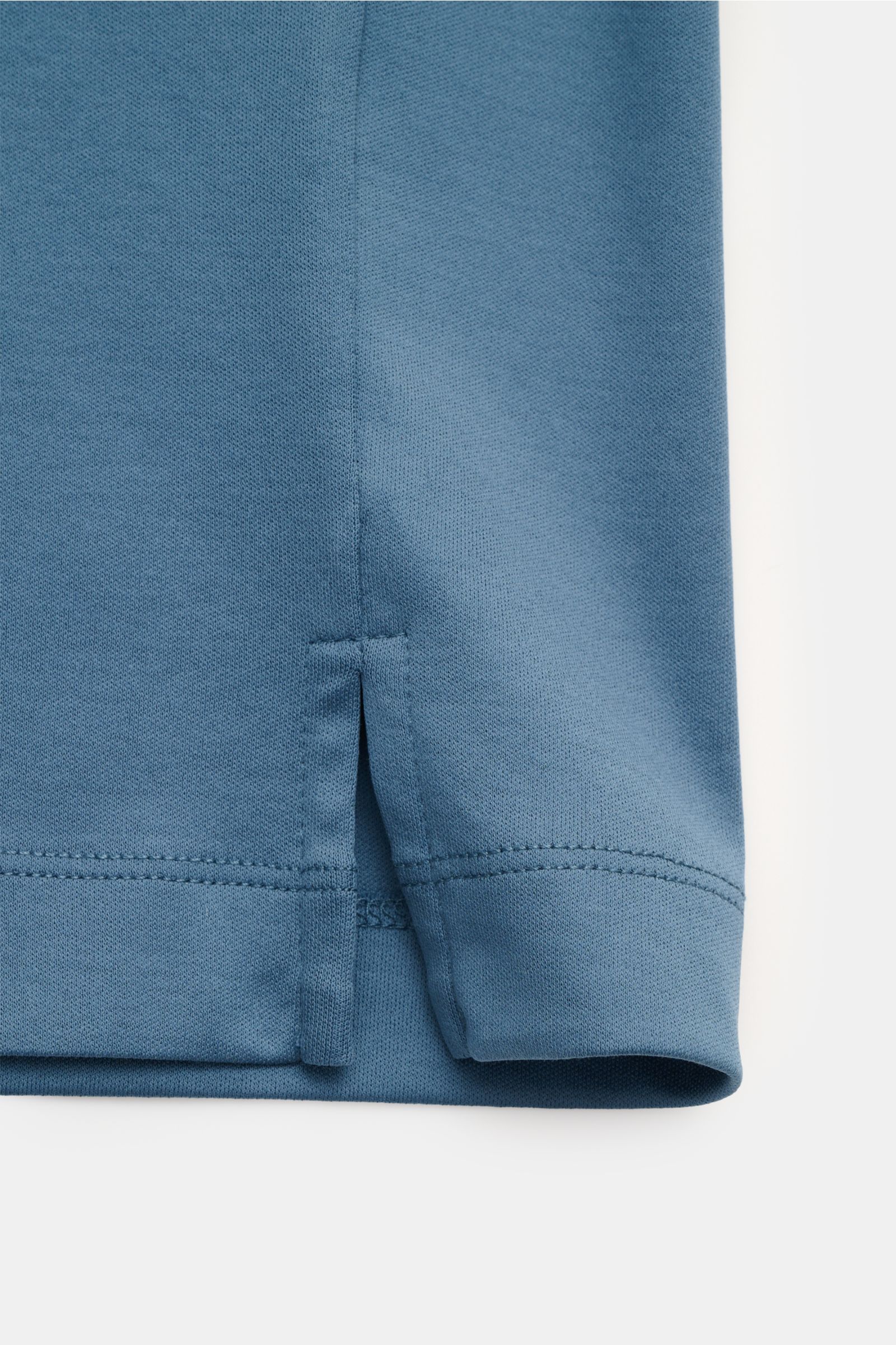 Nahaufnahme des unteren Saumbereichs des Aurélien Rundhals-T-Shirt petrol, Slim Fit aus weicher reiner Baumwolle mit kurzen Saumschlitzen und tonalem Logo-Stitching.