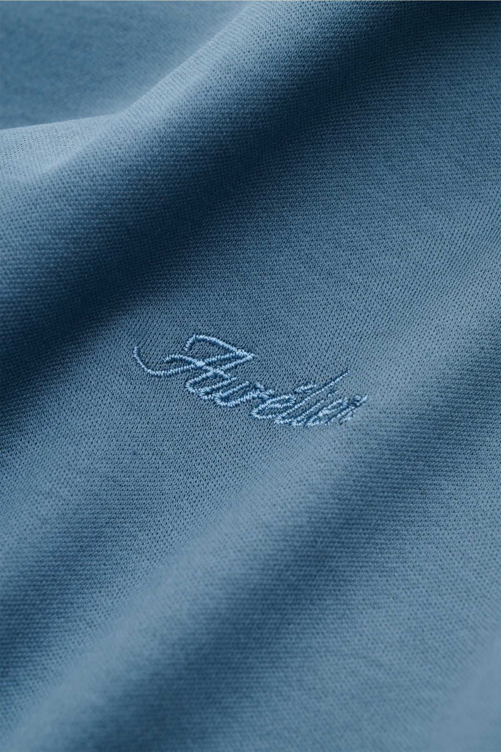 Nahaufnahme des petrolfarbenen Aurélien Rundhals-T-Shirts mit tonalem Logo-Stitching, reiner Baumwolle und weichem Griff.