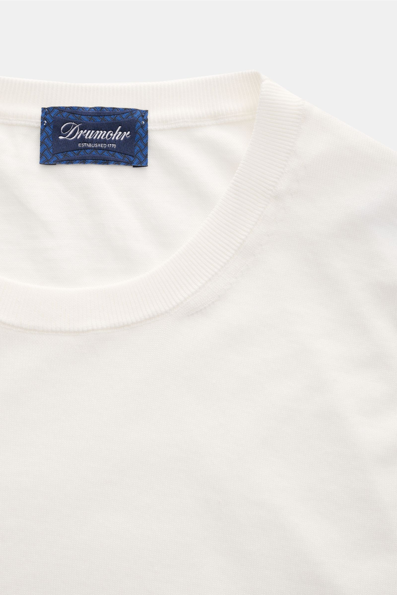 Close-up front view of Drumohr Short sleeve jumper off-white showing fine knit cotton fabric and ribbed neckline with blue Drumohr label. 

Description:  
A fine essential from label DRUMOHR: This Italian-made short sleeve jumper is made of comfortably