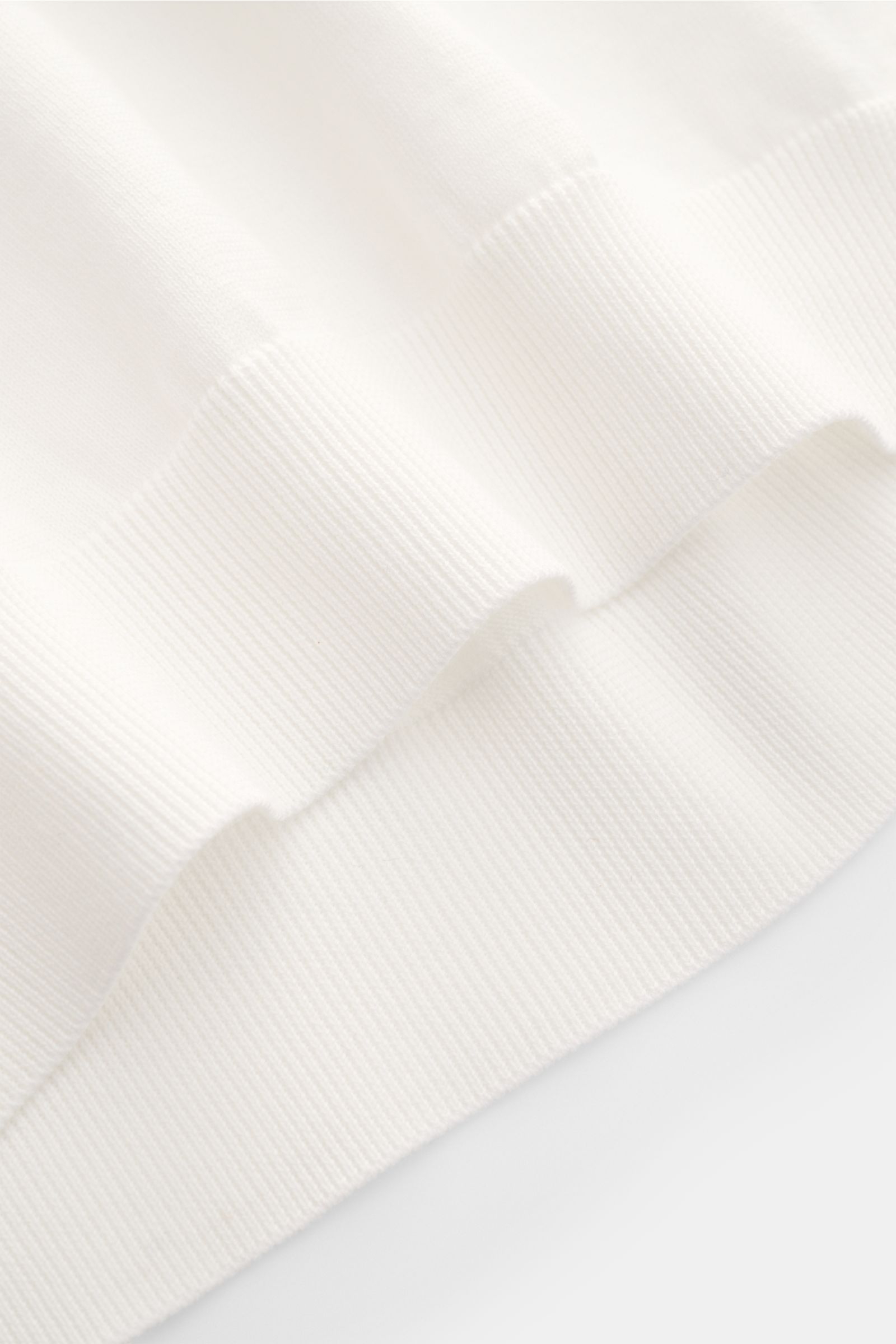 Close-up view of the elasticated ribbed bands of the Drumohr Short sleeve jumper off-white, showcasing its very fine knit and soft cotton fabric.

Description:  
A fine essential from label DRUMOHR: This Italian-made short sleeve jumper is made of comf