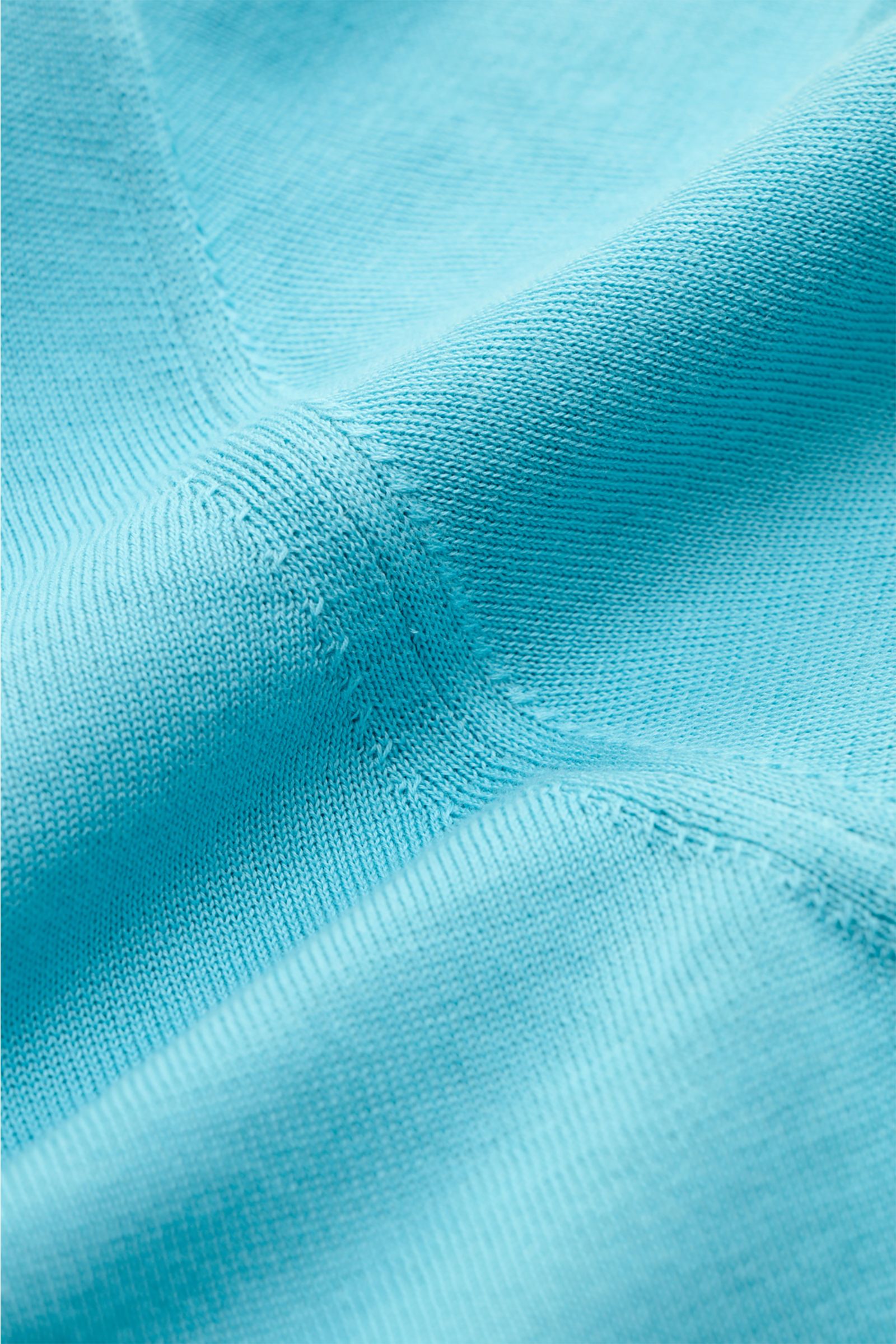 Alt-Tag (124 Zeichen): Nahaufnahme des feinen Strickbilds eines blauen Drumohr Kurzarmpullovers aus weicher Baumwolle, Slim Fit, elastische Bündchen.