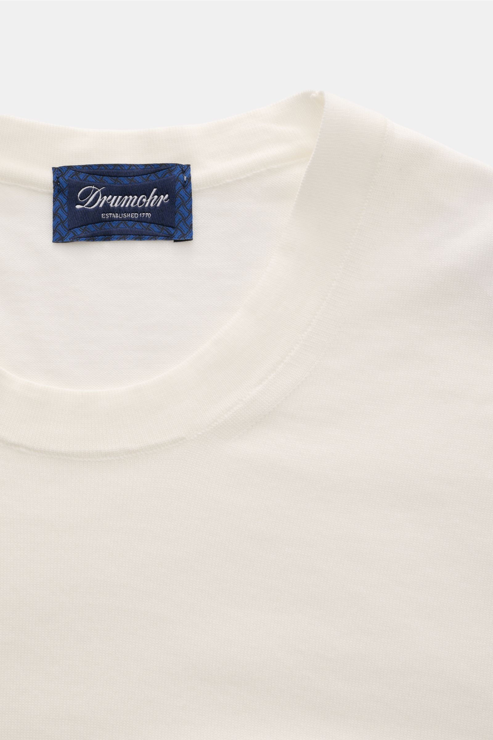 Close-up front view of Drumohr T-shirt off-white showing crew neck and blue label, made of fine knit pure cotton for soft feel and regular fit.

A basic with maximum comfort: This elegant T-shirt by DRUMOHR made of cotton in a comfortable fine knit is 