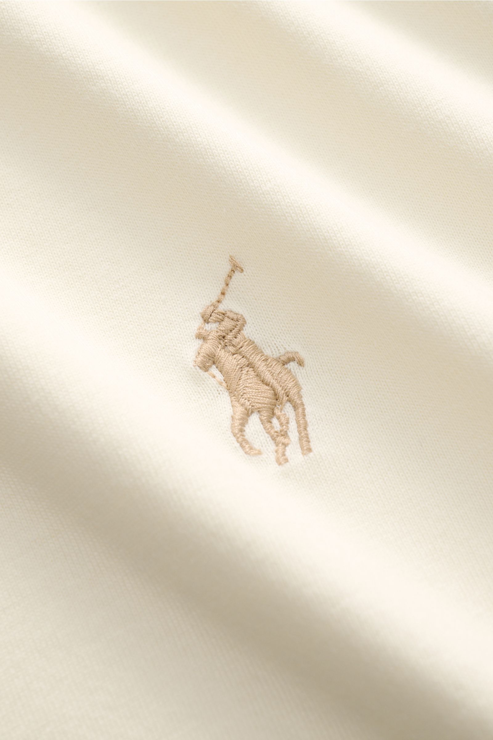 Close-up view of the Polo Ralph Lauren Rundhals-T-Shirt creme showing the beige Polospieler-Stitching on soft, pure cotton jersey fabric.

Das Rundhals-T-Shirt aus Jersey in reiner Baumwolle überzeugt mit seiner weichen Qualität und dem bequemen Slim F