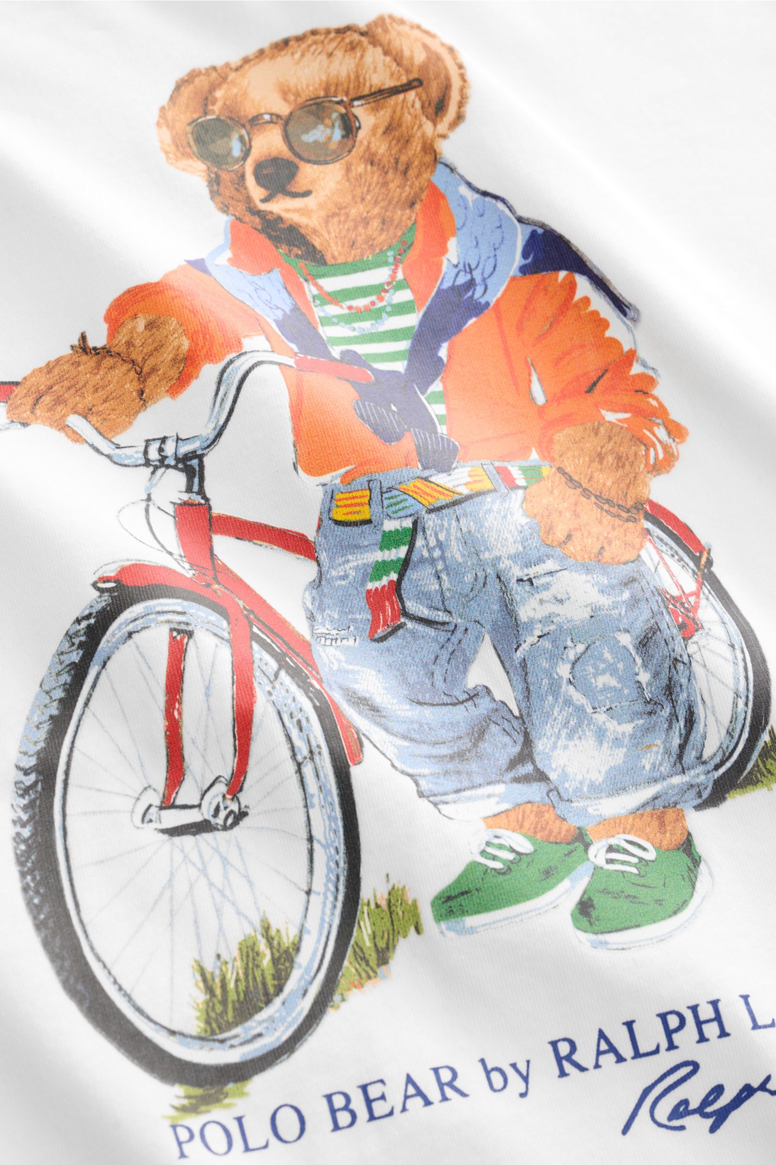 Nahaufnahme des Polo Ralph Lauren Rundhals-T-Shirts weiß mit großem Polo-Bear-Print auf der Brust, fotografiert aus schräger Perspektive, Jersey aus reiner Baumwolle, weiche Qualität, Regular Fit, Rundhalsausschnitt, Statement für warme Tage.