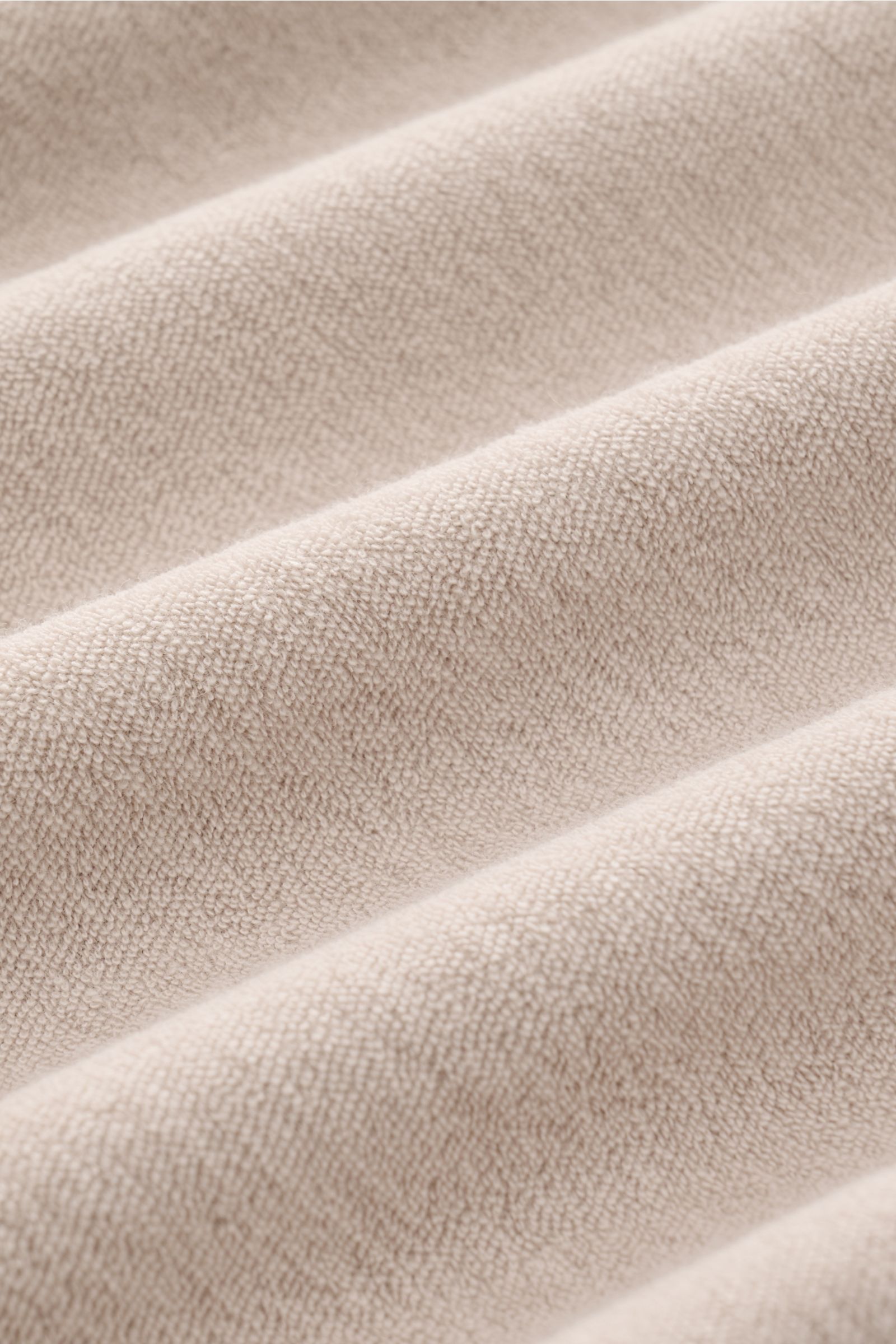 Close-up photo from an angled perspective showing the soft terrycloth texture of the 04651/ A trip in a bag Terry T-shirt 'Terry Tee' beige fabric.

The clean T-shirt 'Terry Tee' by 04651/ A TRIP IN A BAG is made of soft terry in pure cotton fabric and