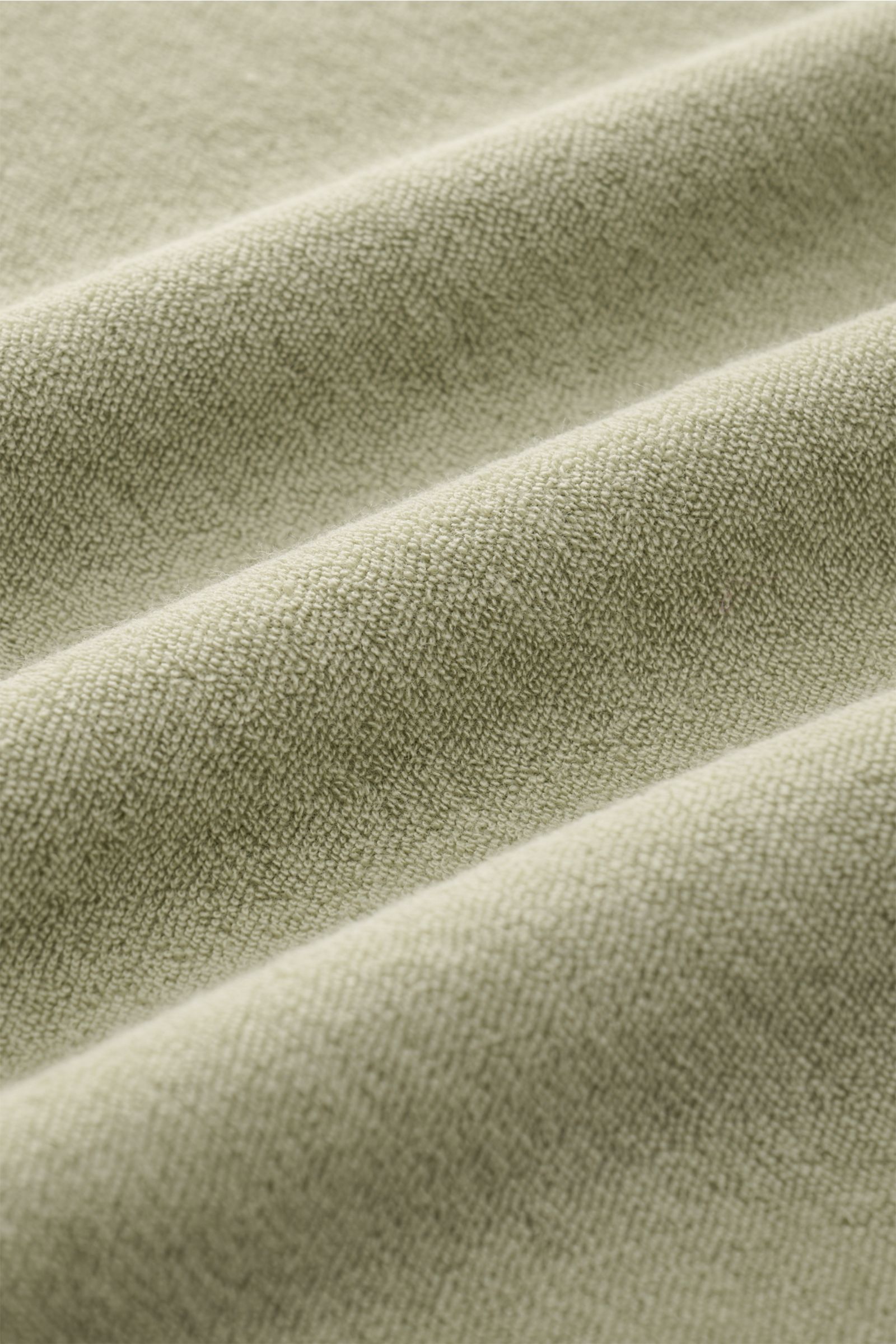 Close-up front angle view of the soft terrycloth fabric in sage color of the 04651/ A trip in a bag Terry T-shirt 'Terry Tee' sage.

The clean T-shirt 'Terry Tee' by 04651/ A TRIP IN A BAG is made of soft terry in pure cotton fabric and is the perfect 