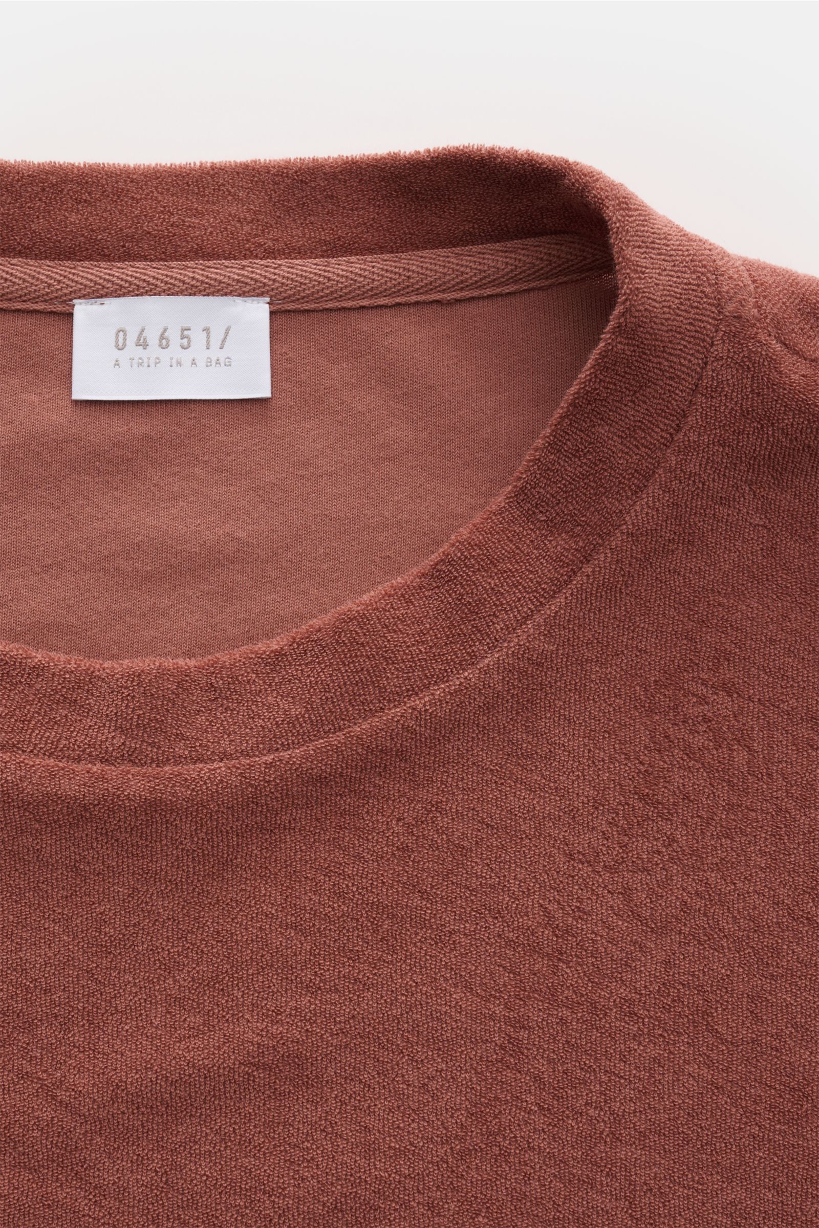 Close-up front view of 04651/ A trip in a bag Terry T-shirt 'Terry Tee' rust brown showing crew neck and soft terrycloth texture.

Description: The clean T-shirt 'Terry Tee' by 04651/ A TRIP IN A BAG is made of soft terry in pure cotton fabric and is t