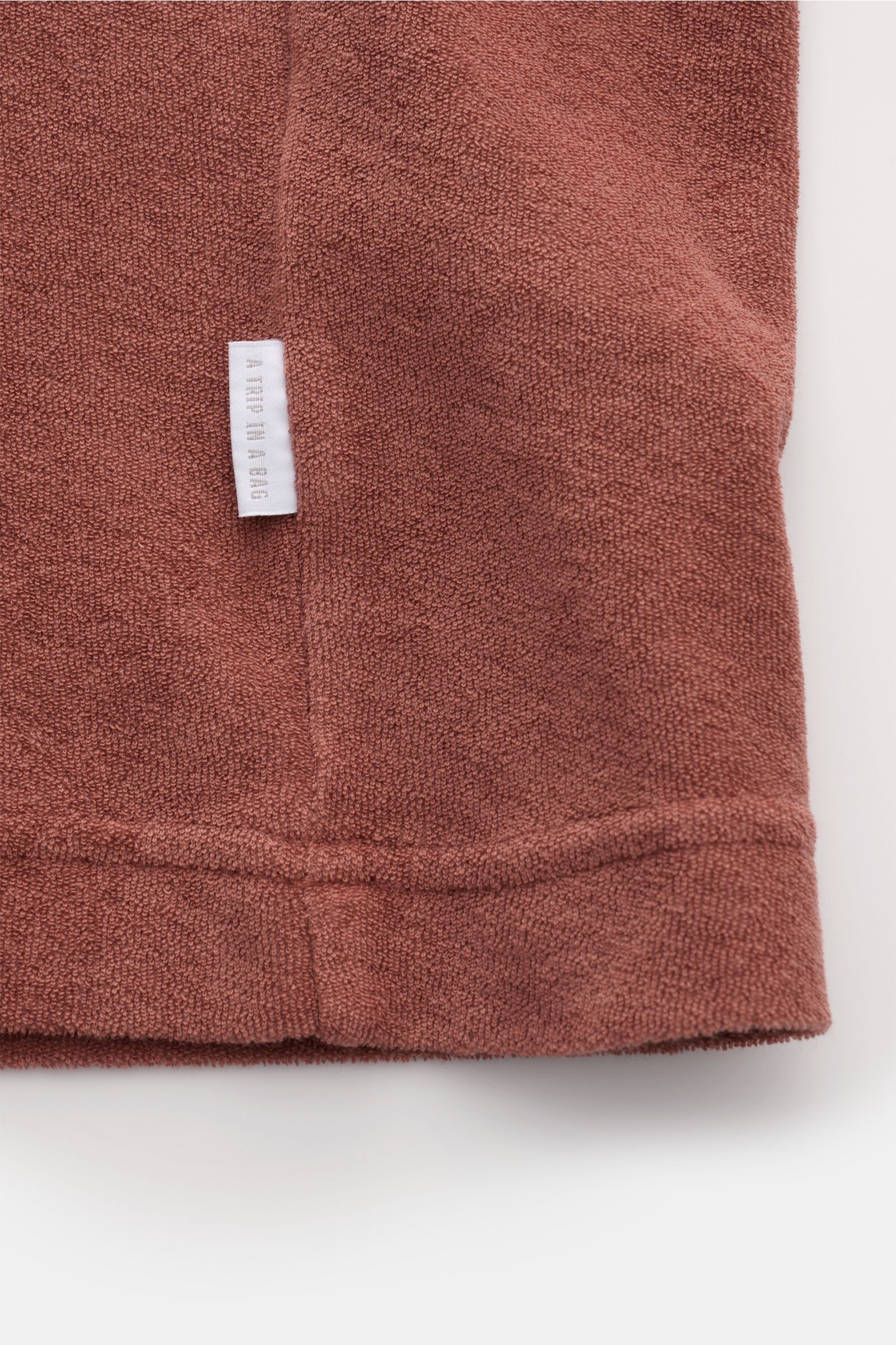 Close-up side view of 04651/ A trip in a bag Terry T-shirt 'Terry Tee' rust brown showing soft terrycloth texture and small woven side seam label.

The clean T-shirt 'Terry Tee' by 04651/ A TRIP IN A BAG is made of soft terry in pure cotton fabric and 